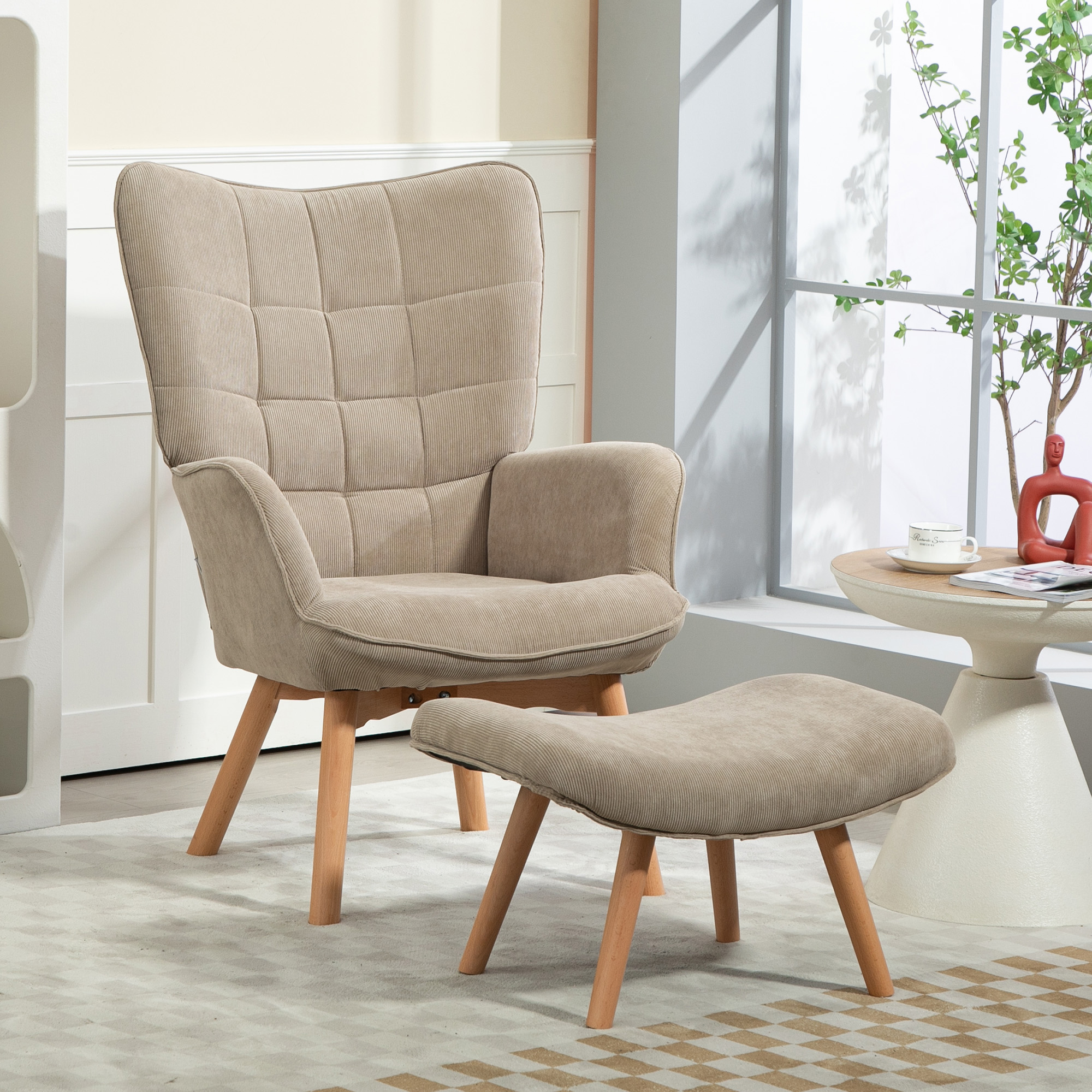 Una poltrona beige con un pouf abbinato su un tappeto fantasia. Un tavolino con una tazza e una scultura rossa.