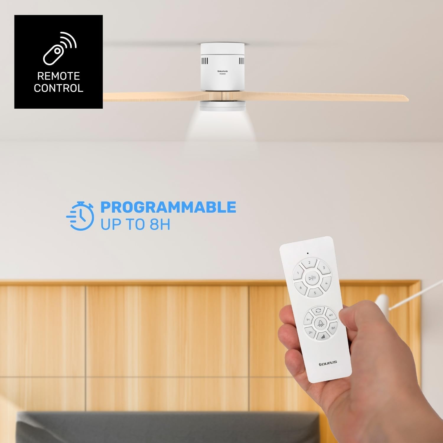 Una persona sostiene un mando a distancia para un ventilador de techo. El ventilador es blanco con aspas de madera. El mando tiene botones.