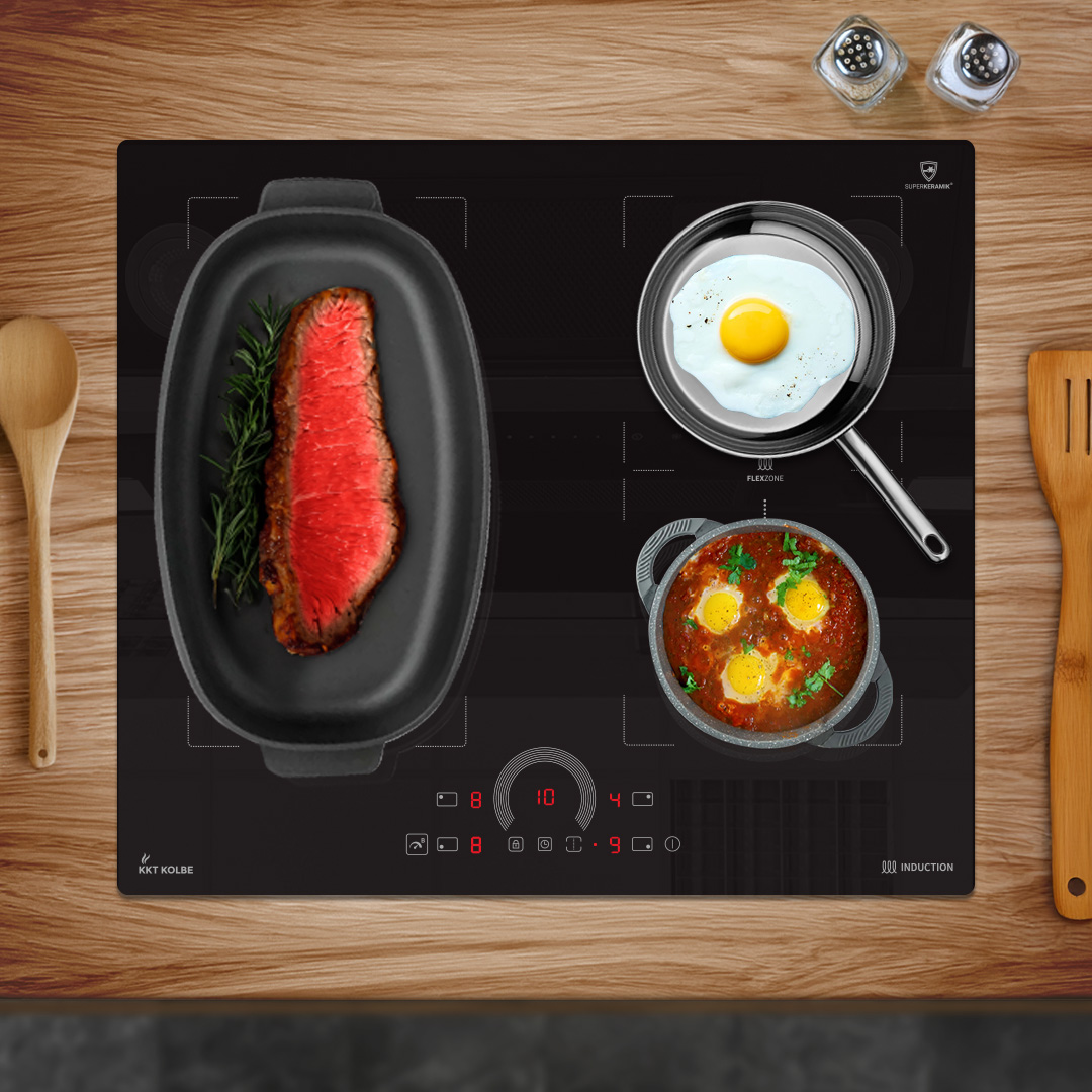 Ein schwarzes Induktionskochfeld mit Steak, Spiegelei und Eintopf. Holzlöffel und -spatel auf einem Holztisch.