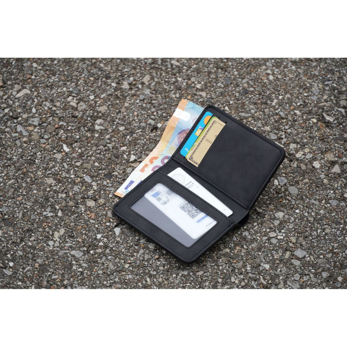 A black wallet with cards and euro bills on a textured gray surface. The wallet is open, displaying contents.