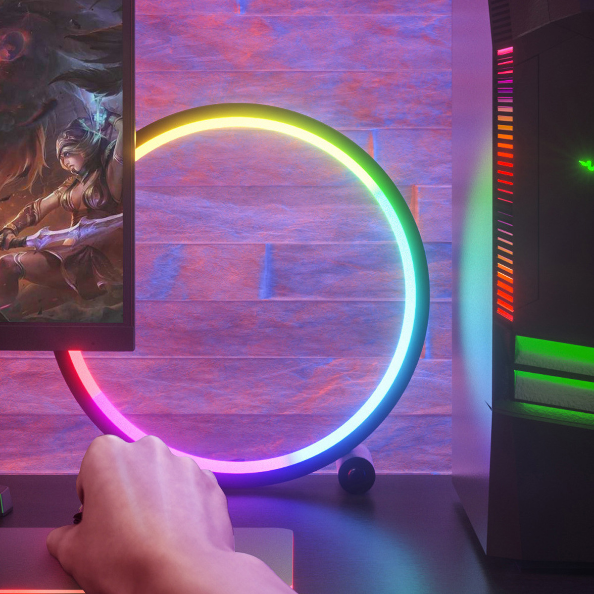 Eine Hand benutzt eine Maus in der Nähe eines Desktops. Ein Monitor zeigt ein Spiel. Ein leuchtender Ring und ein Computergehäuse sind ebenfalls vorhanden.