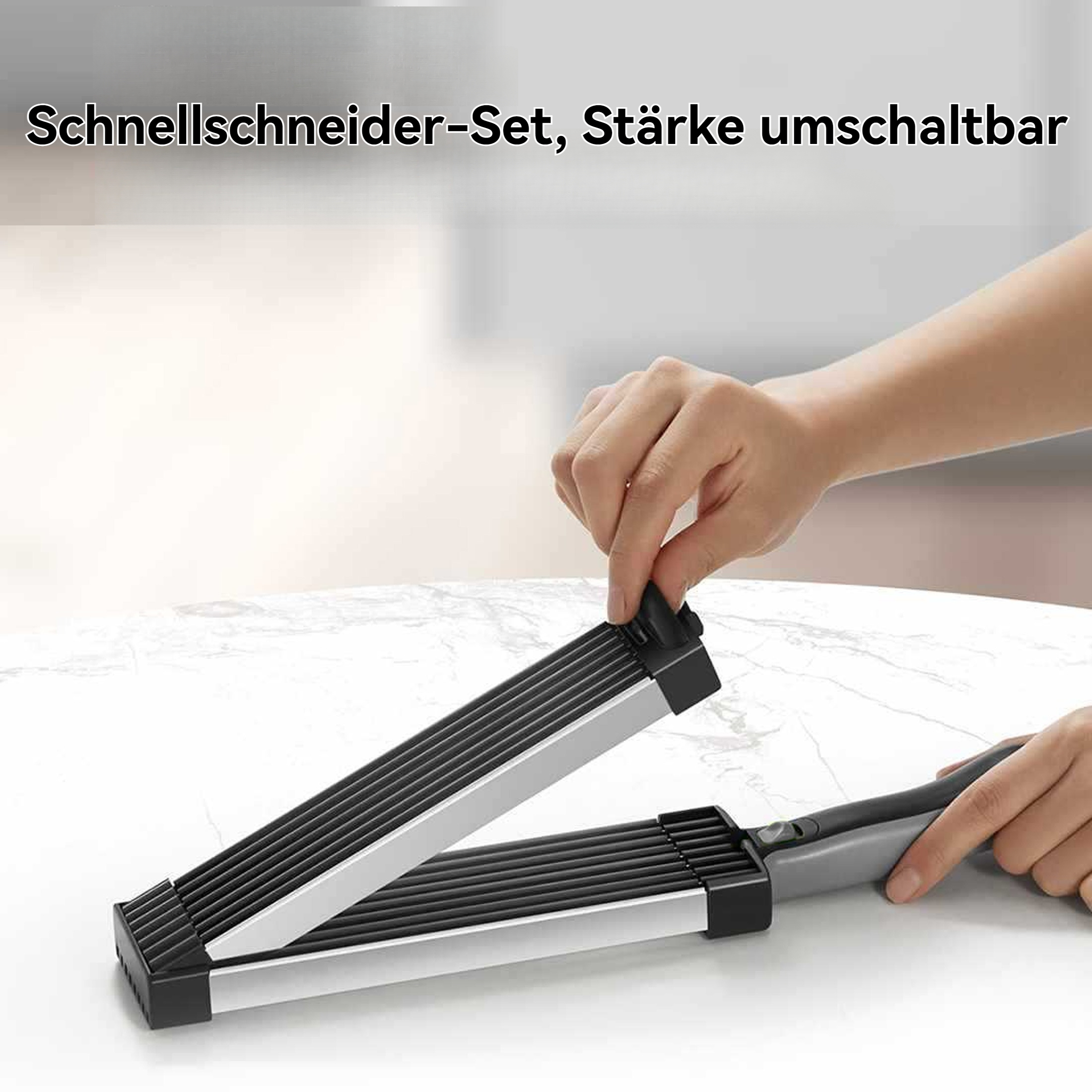 Hände halten einen schwarz-silbernen Schneider auf einer Marmoroberfläche. Der Schneider ist auf Deutsch beschriftet.