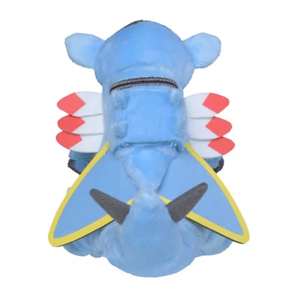 Blaues Plüschflugzeug, Draufsicht. Merkmale: weiße Flügel mit roten Spitzen, gelbe und schwarze Akzente und graue propellerartige Formen.