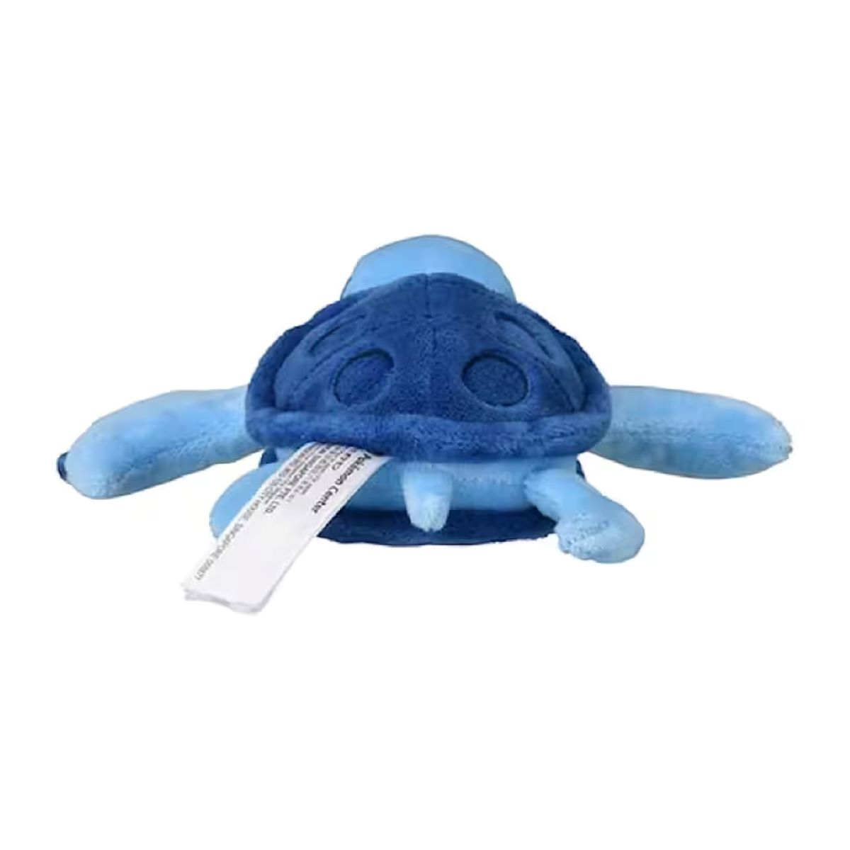 Ein blaues Plüschtier, das einer Schildkröte ähnelt. Es hat einen dunkelblauen Panzer und hellblaue Gliedmaßen. Ein Etikett mit Text ist angebracht.