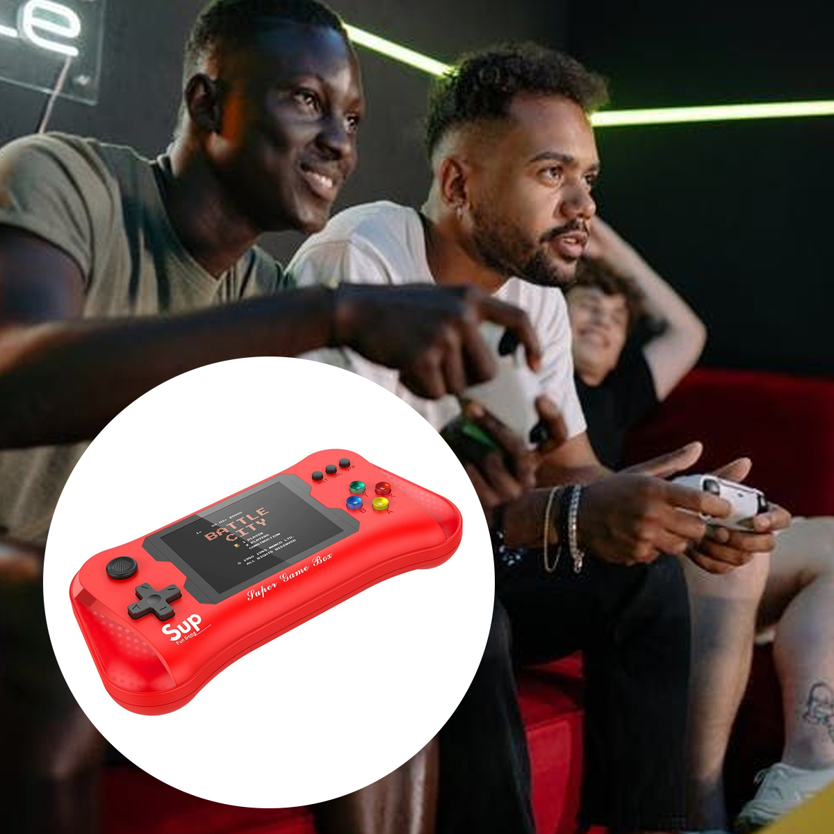 Drei Männer spielen Videospiele. Eine rote Handheld-Konsole befindet sich im Vordergrund. Zwei Männer lächeln. Einer hält einen Controller.