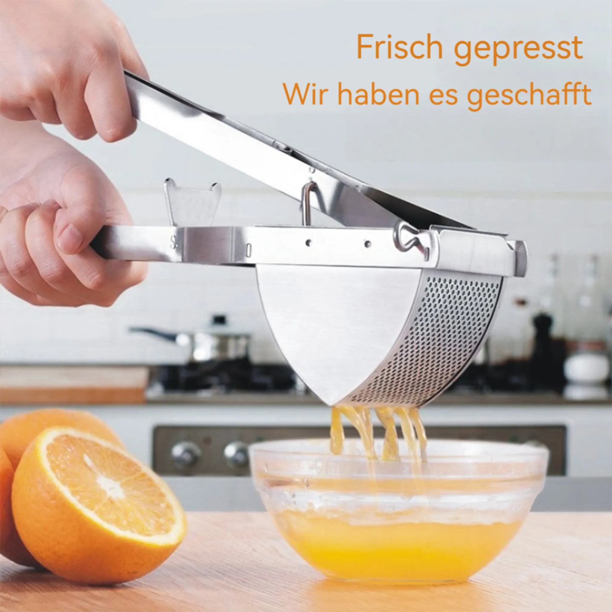 Hand presst Saft aus einer halben Orange mit einer Saftpresse in eine Glasschüssel. Im Hintergrund ist eine Küche zu sehen.