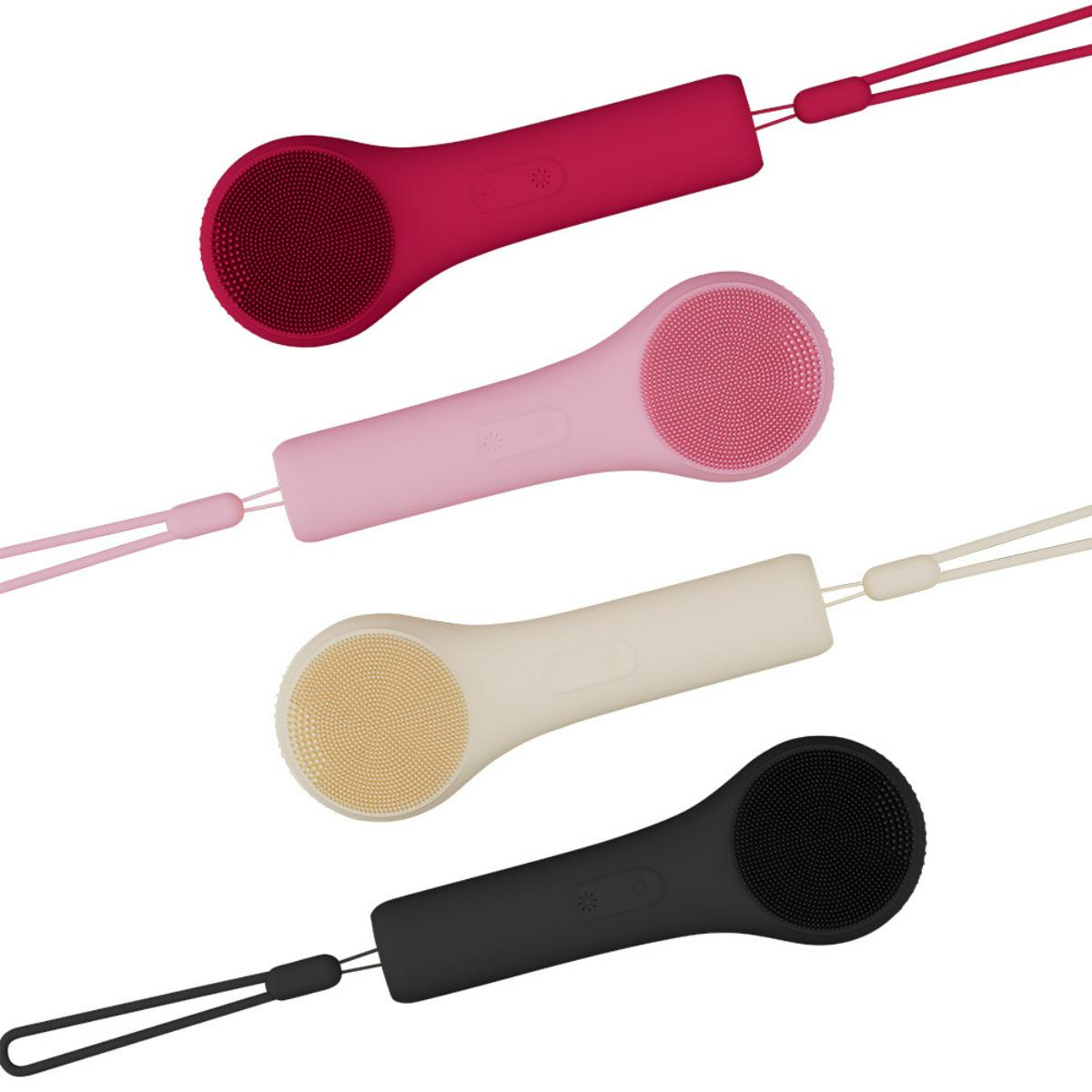 Vier farbige Gesichtsreinigungsbürsten auf weißem Hintergrund. Jede hat eine andere Farbe: Rot, Rosa, Beige und Schwarz. Alle haben eine Schlaufe.