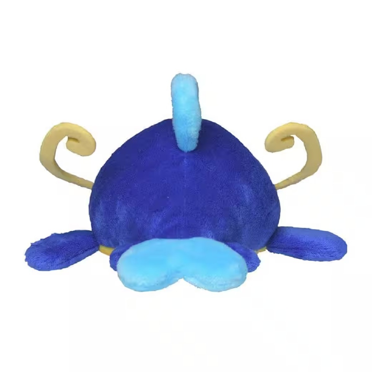 Ein Plüschtier, blauer Körper mit hellblauen Akzenten und gelben Hörnern. Es ähnelt einer Zeichentrickfigur, die auf weißem Hintergrund liegt.