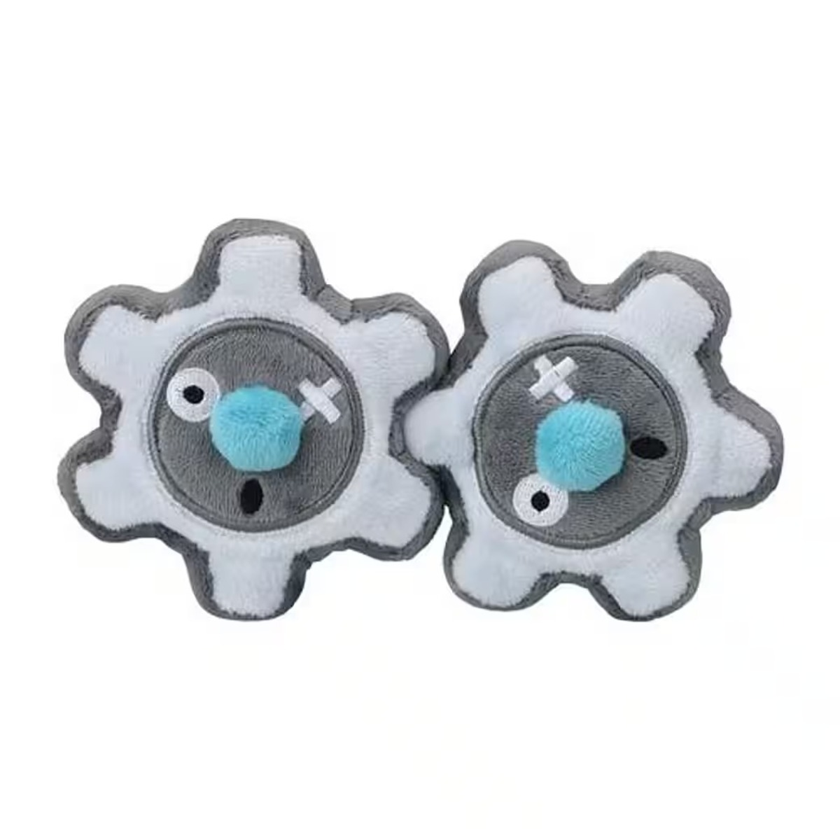 Zwei Plüsch-Zahnradspielzeuge. Jedes hat weiße Zahnradzähne, eine graue Mitte, einen blauen Bommel und kreuzförmige Nahtdetails.