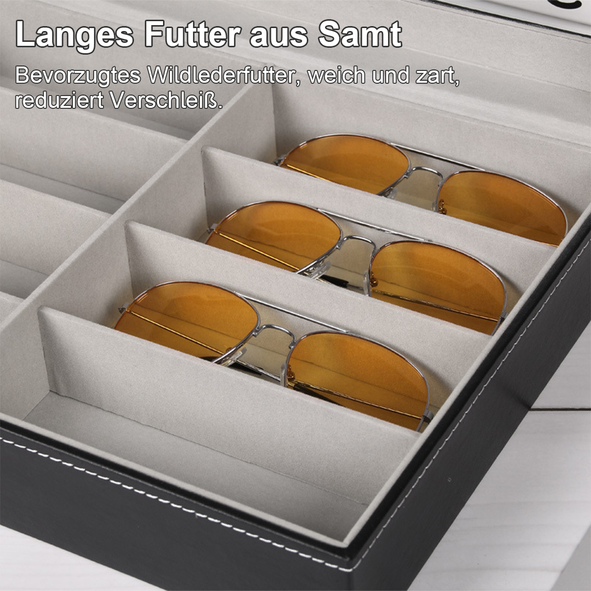 Sonnenbrillen in einer schwarzen Box. Drei Sonnenbrillen mit gelben Gläsern sind darin. Die Box ist mit hellgrauem Stoff ausgekleidet.
