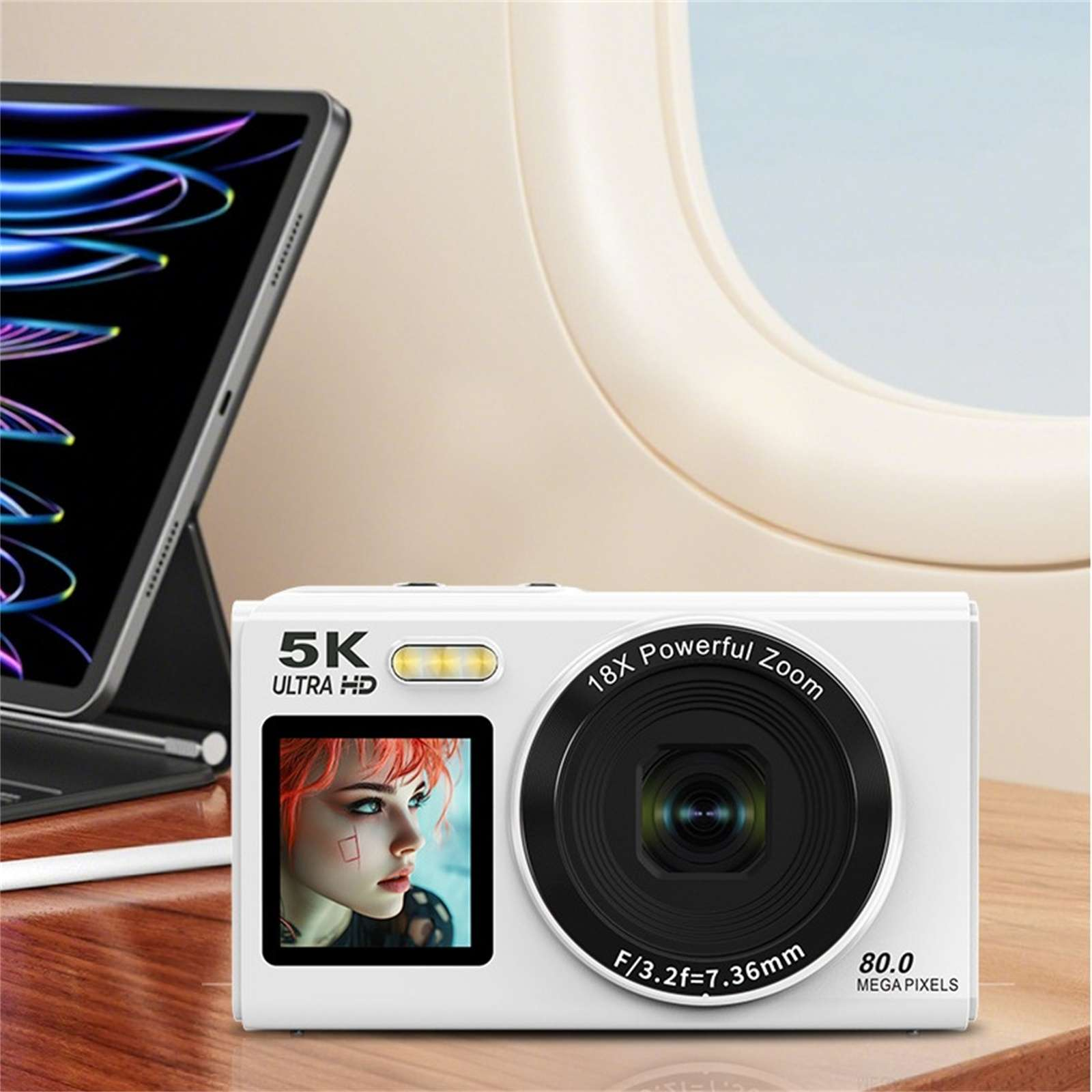 Weiße Kamera mit Bildschirm, der eine Person zeigt. Im Hintergrund sind ein Tablet und ein Flugzeugfenster zu sehen.