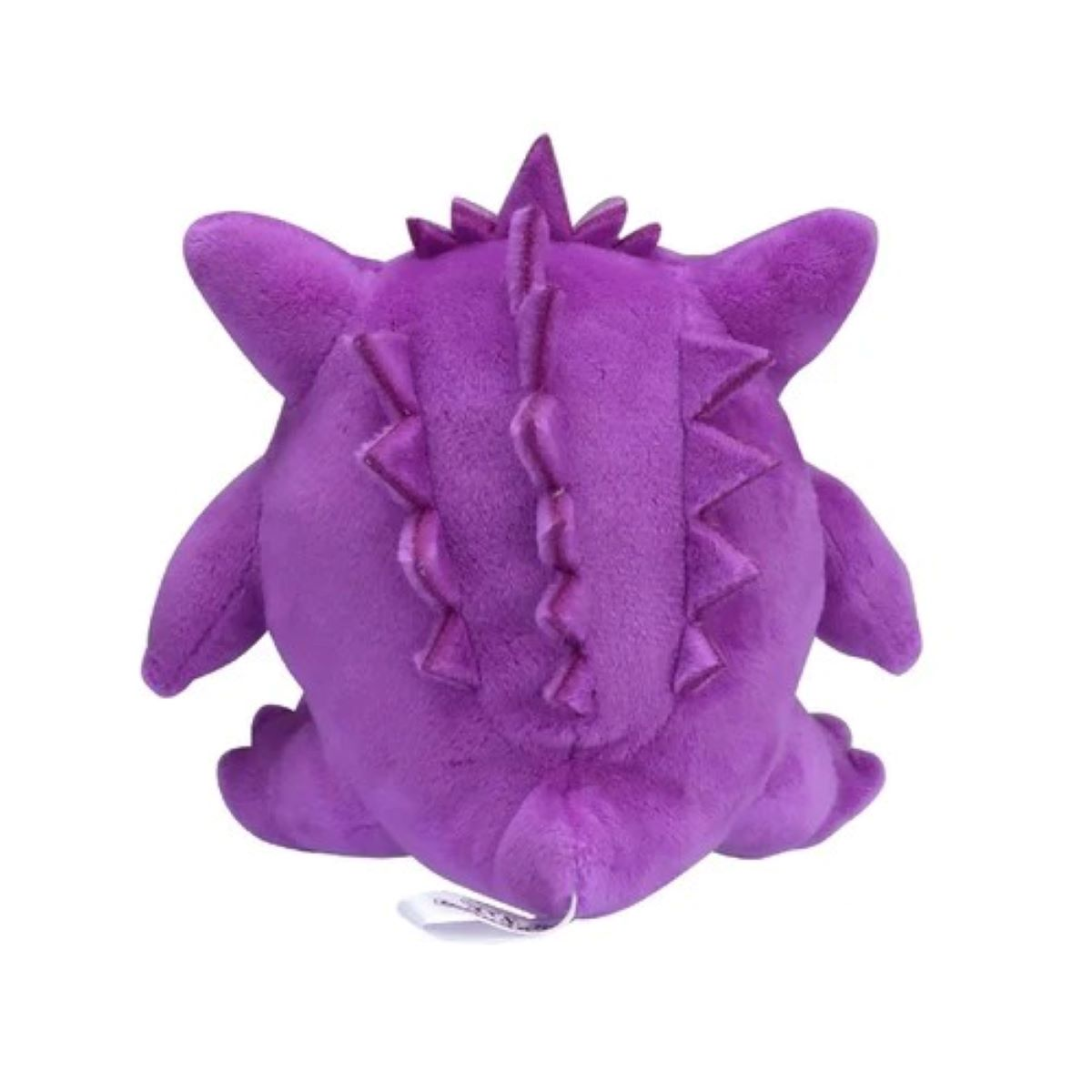 Ein lila Plüsch-Gengar-Spielzeug ist von hinten zu sehen. Es hat einen stacheligen Rücken und Ohren, mit einem Schwanz und einem weißen Etikett unten.