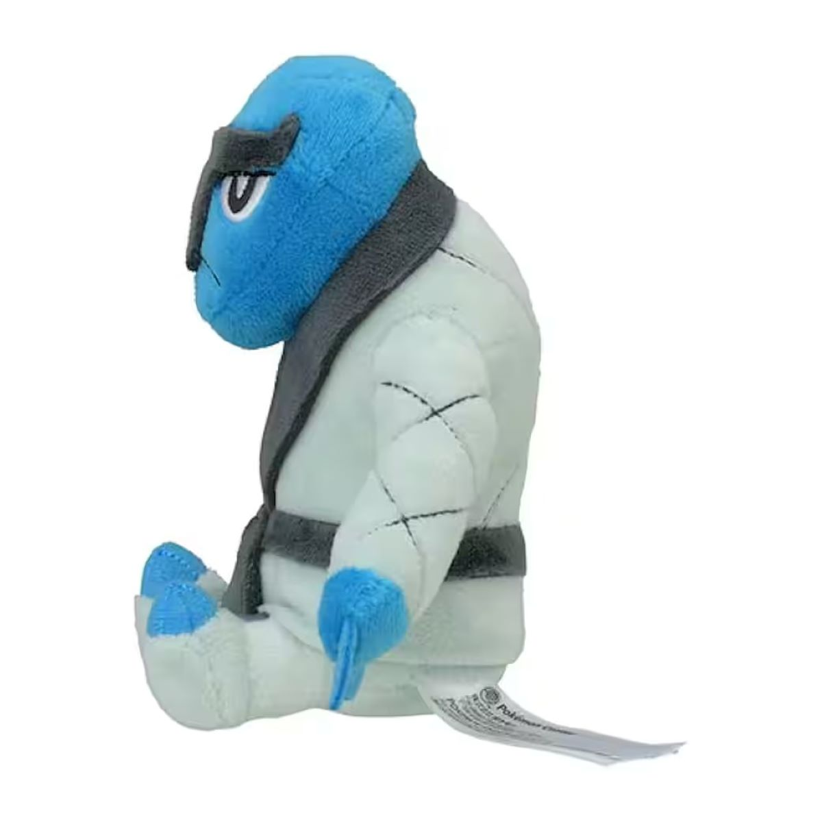Ein blau-weißes Plüschtier in einem Karate-Gi. Es hat einen blauen Kopf, graue Akzente und ein weißes Outfit. Es sitzt.