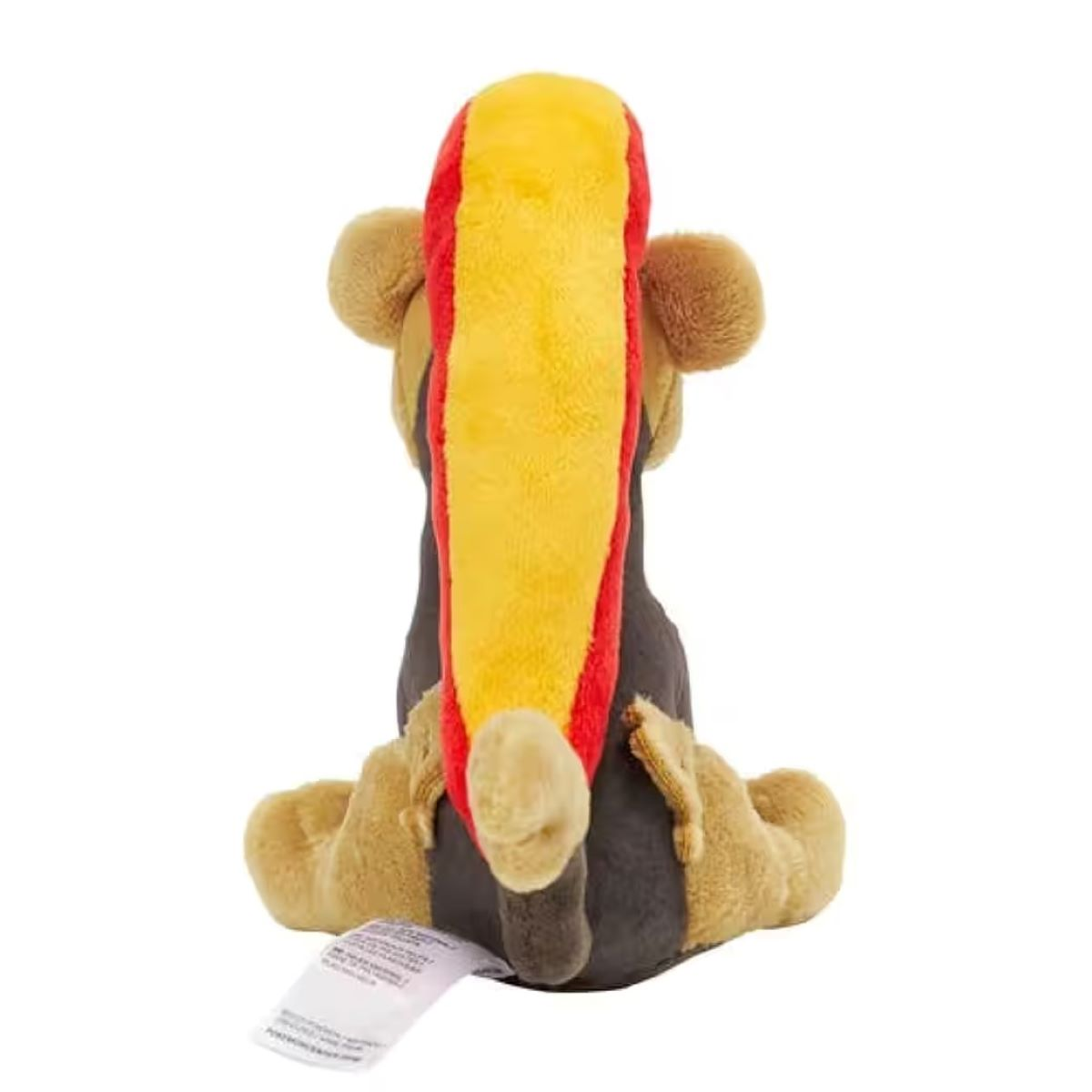 Ein Stofftier, hundeartig, von hinten gesehen. Gelb, rot und braun sind vorherrschend. Ein Etikett hängt am Boden des Spielzeugs.