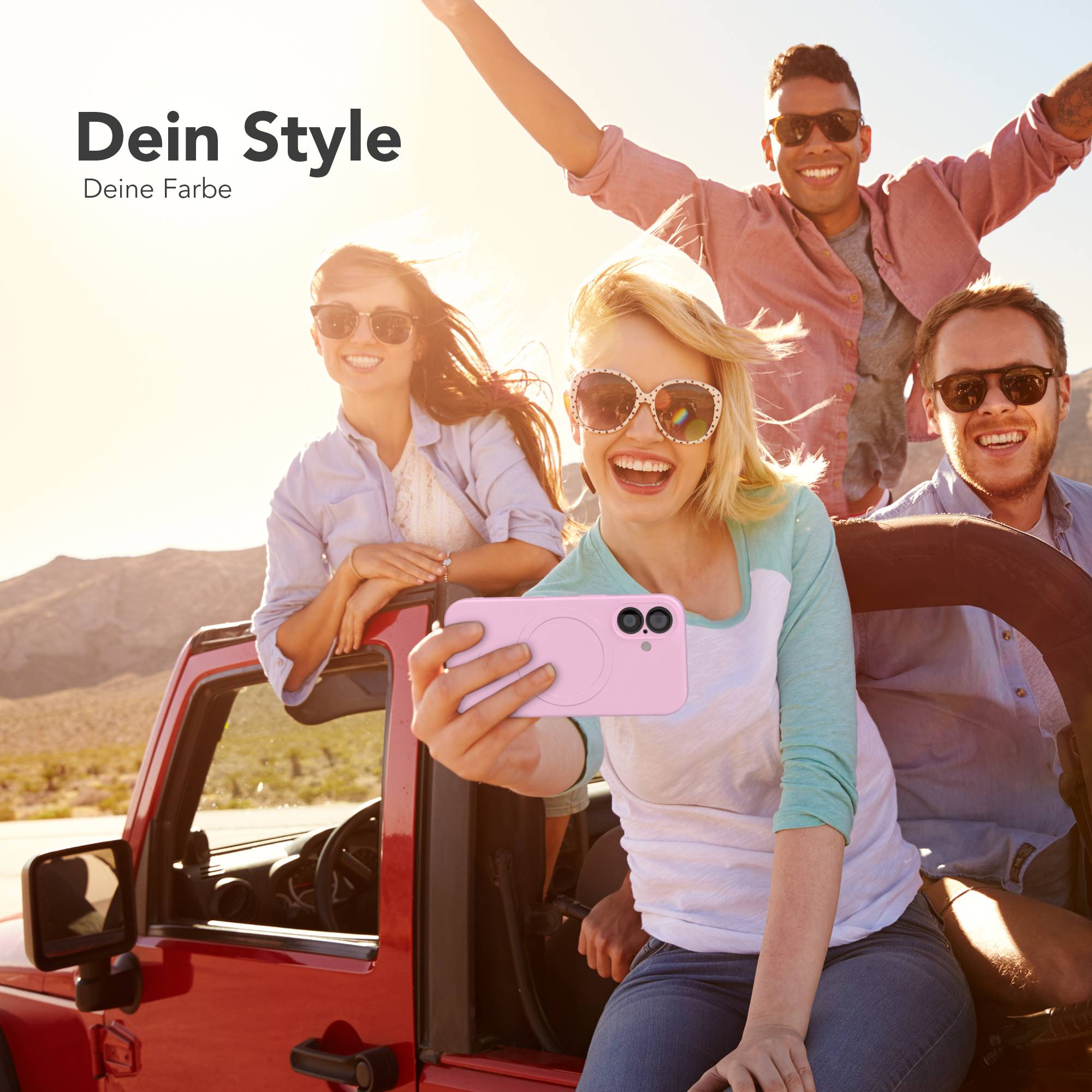 Vier Freunde in einem roten Jeep machen ein Selfie. Einer hält eine pinkfarbene Handyhülle. Sie lächeln und tragen Sonnenbrillen.