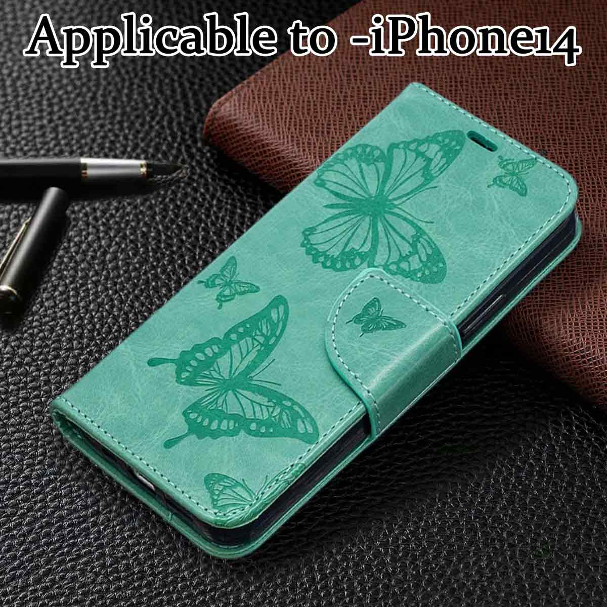 Grüne iPhone 14 Hülle mit Schmetterlingsdesign. Auf strukturierter Oberfläche. Braune Geldbörse im Hintergrund. Stift links.