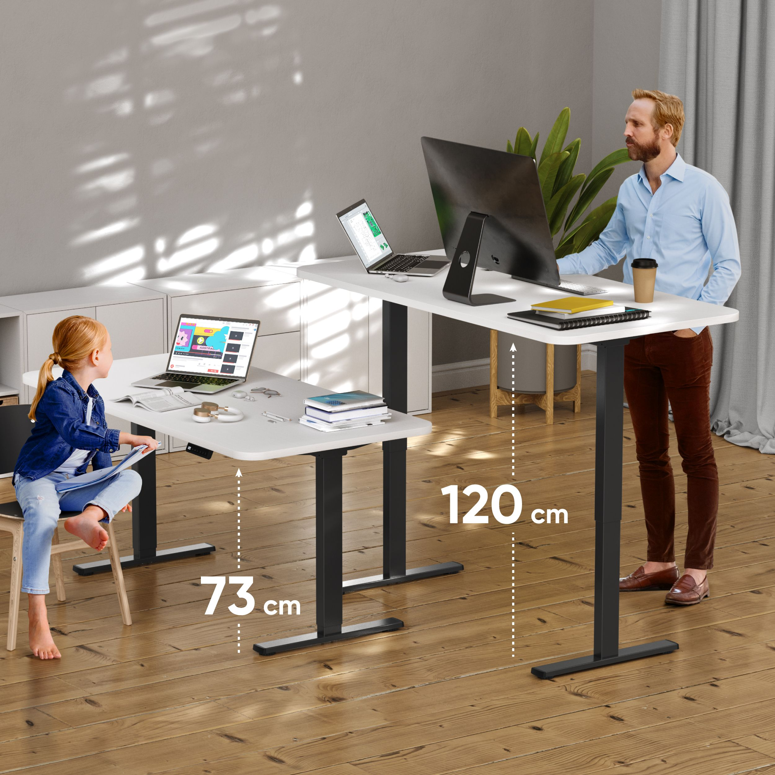 Ein Mann und ein Mädchen in der Nähe weißer Schreibtische mit Laptops. Ein Monitor befindet sich auf dem rechten Schreibtisch.