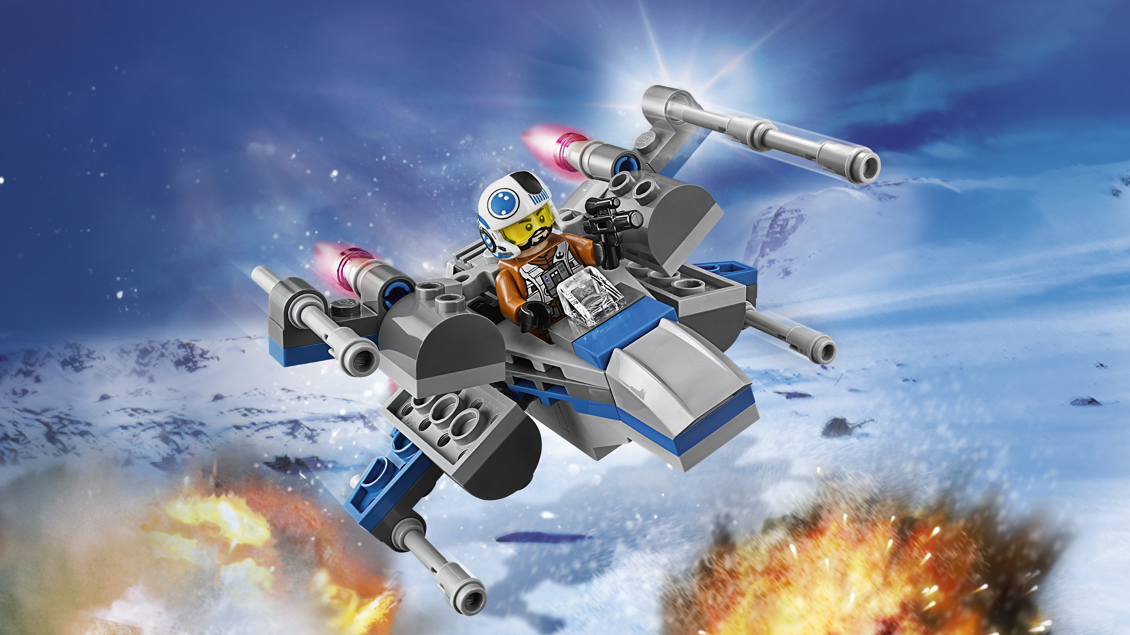 Myśliwiec X-wing Lego w locie, pilotowany przez minifigurkę. Scena obejmuje zaśnieżoną planetę i eksplozje.