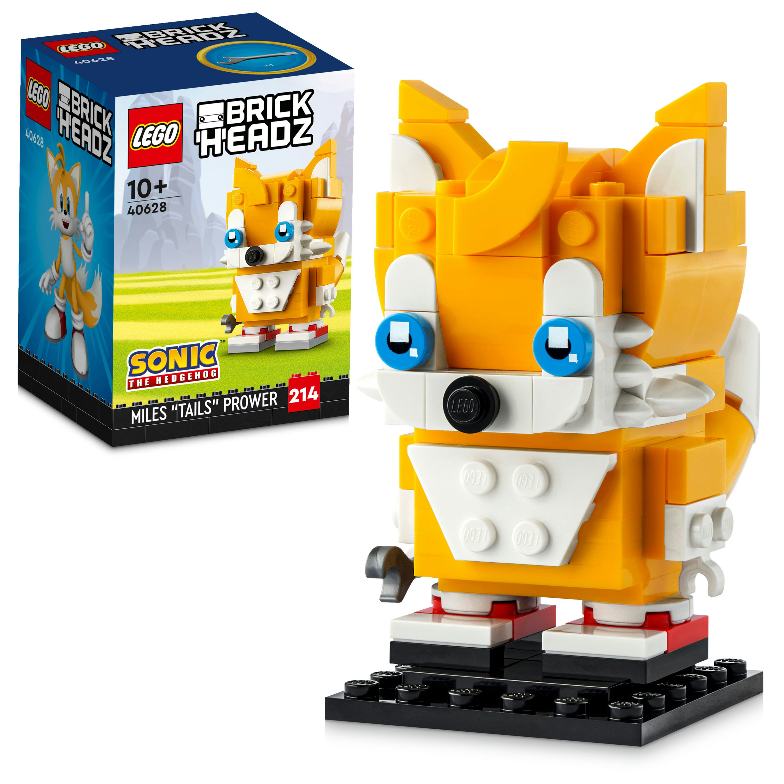 Eine Lego BrickHeadz Miles "Tails" Prower Figur mit einer Box links. Die Figur ist gelb, weiß und schwarz.