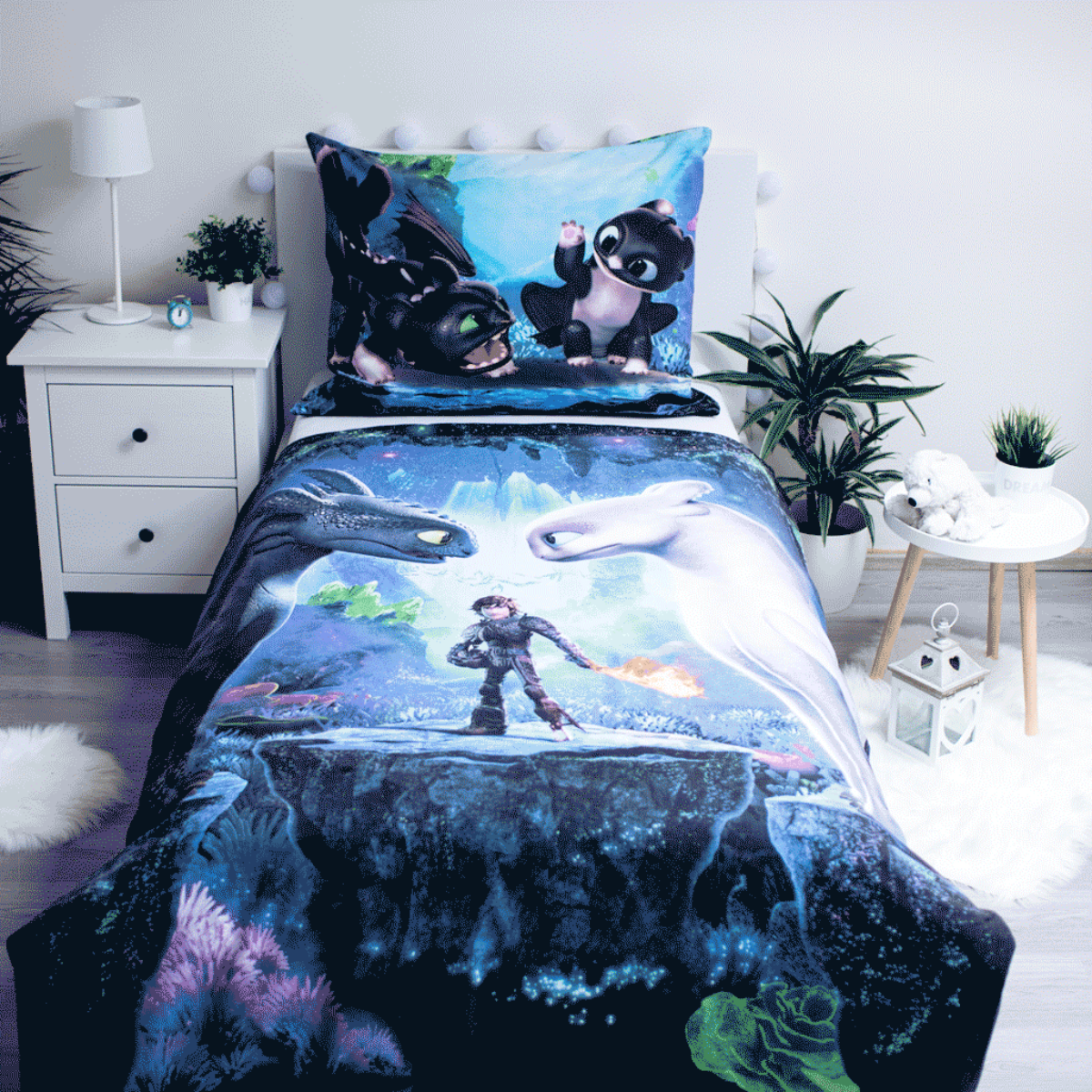 Bettwäsche-Set mit Drachen und einem Jungen mit Feuer. Die Szene ist blau und schwarz. Weißer Nachttisch und Lampe sind links.