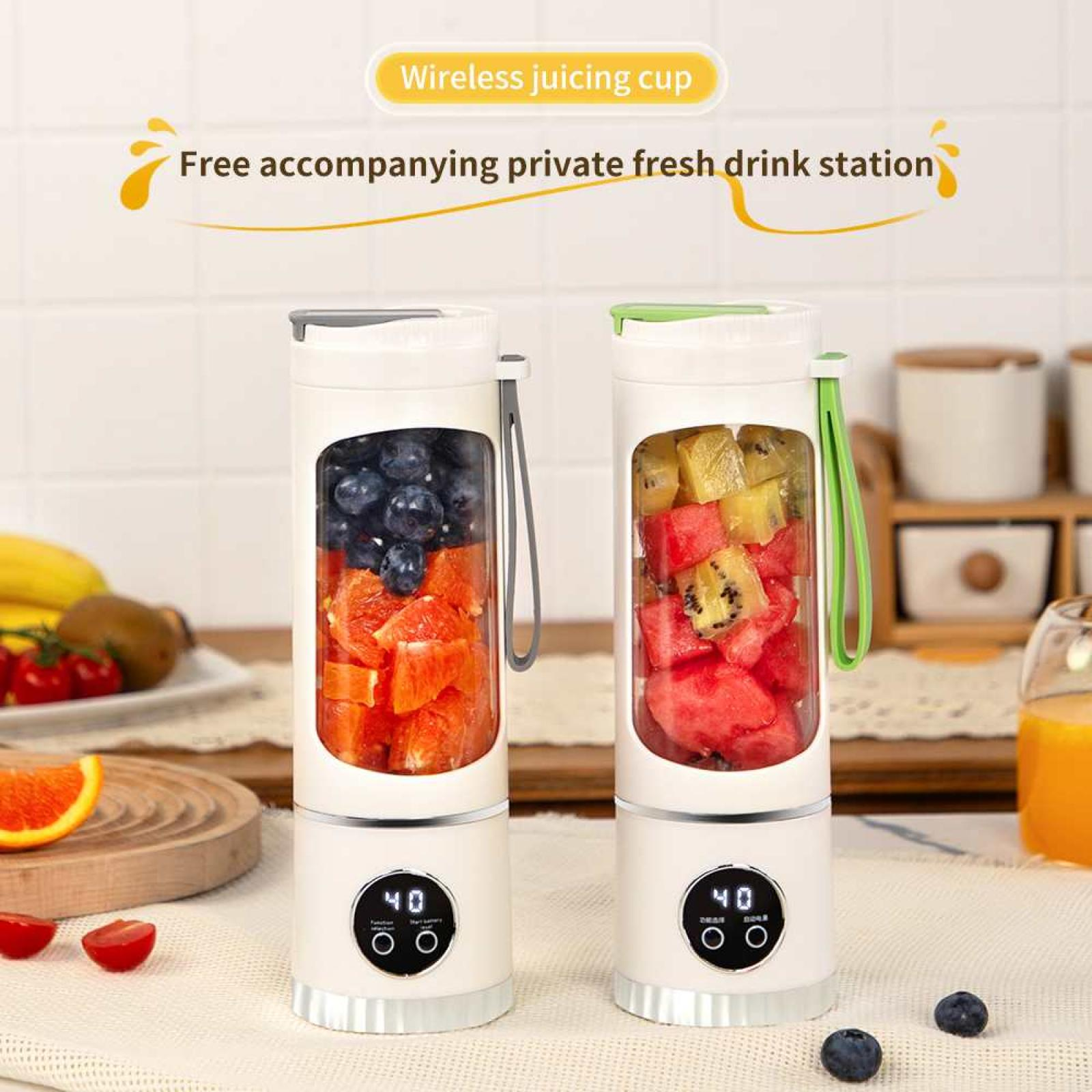 Zwei weiße Entsafter mit Früchten im Inneren. Einer hat Orangen und Blaubeeren, der andere Wassermelone und Kiwi. Früchte liegen auf einem Tisch.