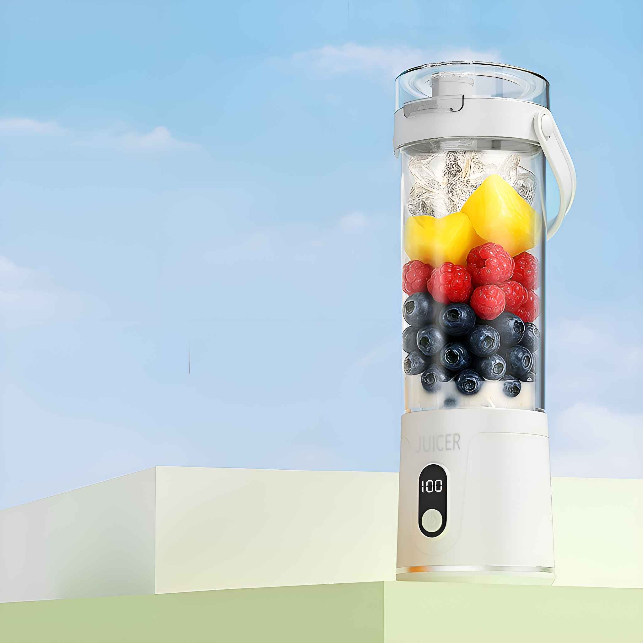 Ein weißer Entsafter mit Früchten darin, auf einer weißen Plattform, vor blauem Himmel. Früchte sind Ananas, Himbeeren, Blaubeeren.