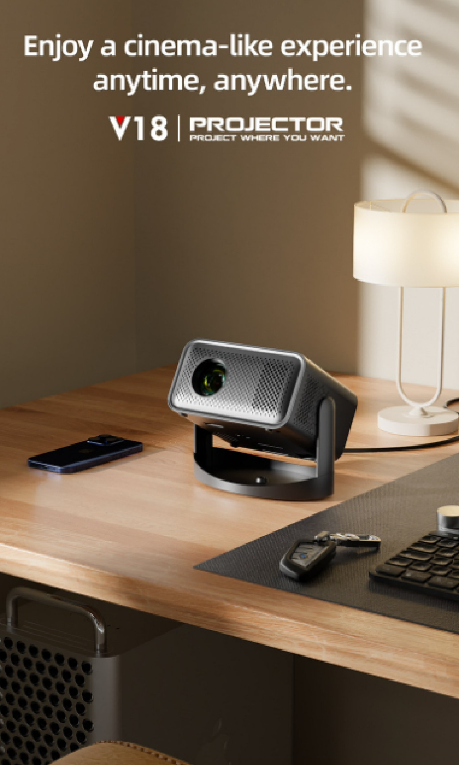 Ein Projektor auf einem Schreibtisch. Ein Telefon, Schlüssel und Tastatur sind ebenfalls vorhanden. Eine Lampe steht im Hintergrund. Der Text lautet 'V18 PROJECTOR'.
