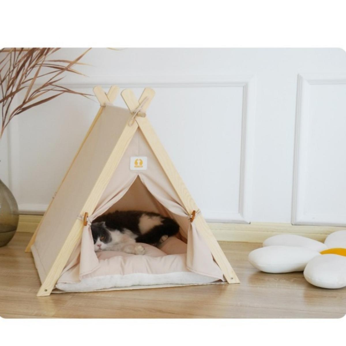 Eine Katze liegt in einem beigen Zelt-Haustierbett. Das Bett steht auf einem Holzboden. Ein weißes blütenförmiges Kissen liegt auf dem Boden.
