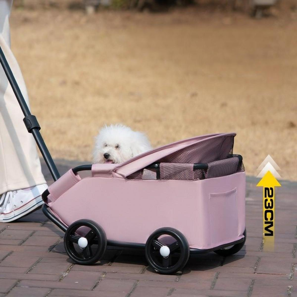 Ein kleiner weißer Hund in einem rosa Haustierkinderwagen wird auf einem Ziegelweg geschoben. Die Beine einer Person sind neben dem Kinderwagen.
