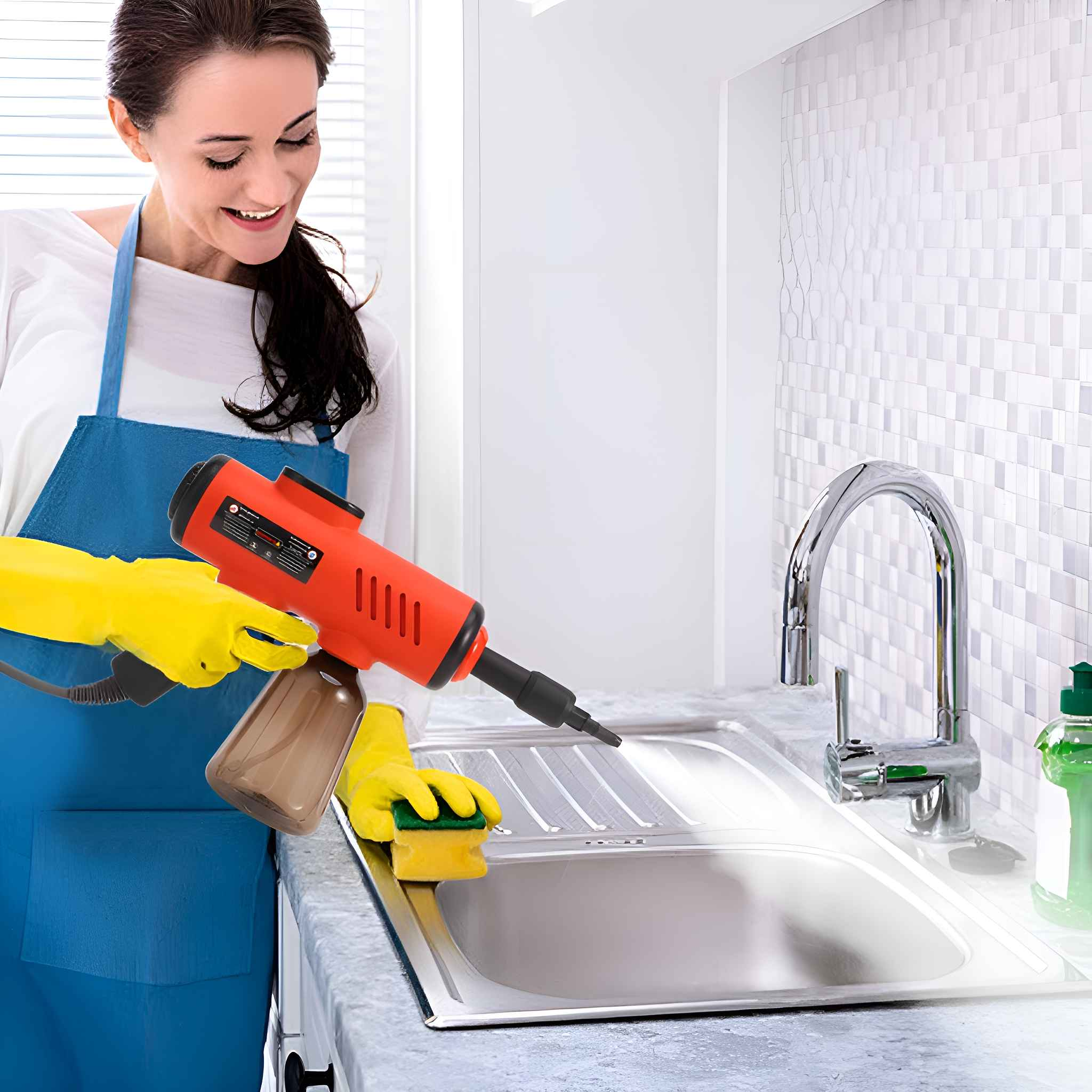 Eine Frau in blauer Schürze und gelben Handschuhen benutzt eine rote Reinigungsmaschine an einem Waschbecken.