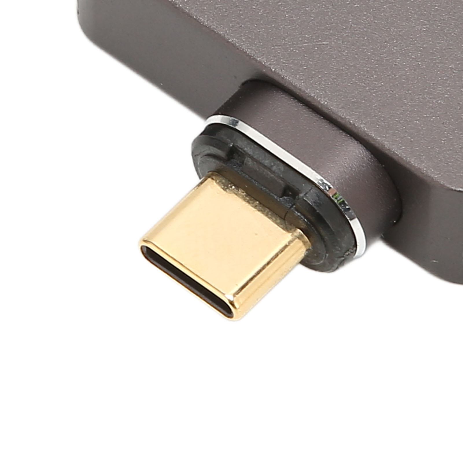 Nahaufnahme eines USB-C-Anschlusses mit goldfarbener Spitze und grauem, strukturiertem Gehäuse. Ein silberner Ring umrandet den Anschluss.