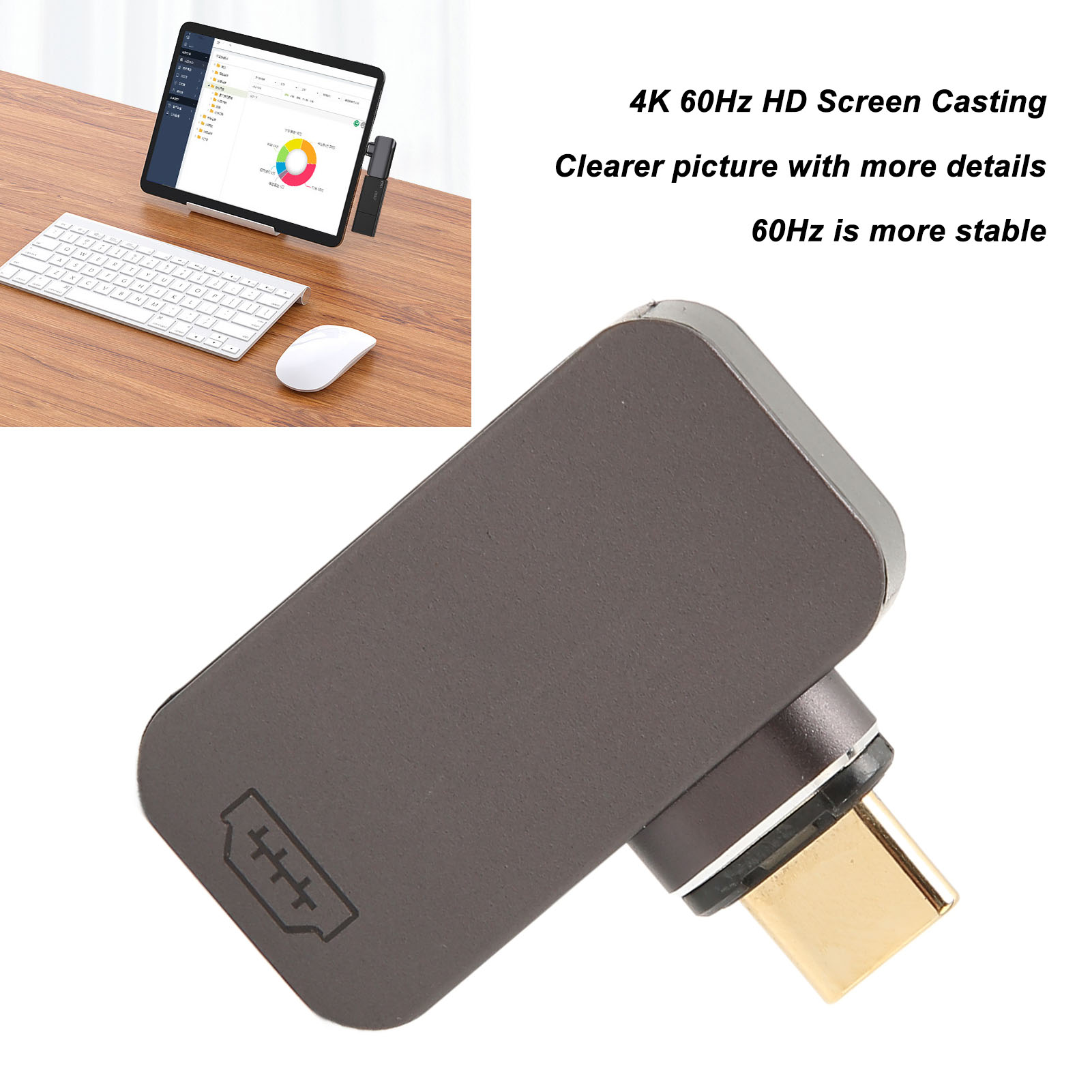 Ein grauer Adapter mit goldenem Stecker auf weißem Grund. Tablet, Tastatur und Maus auf Holzoberfläche.