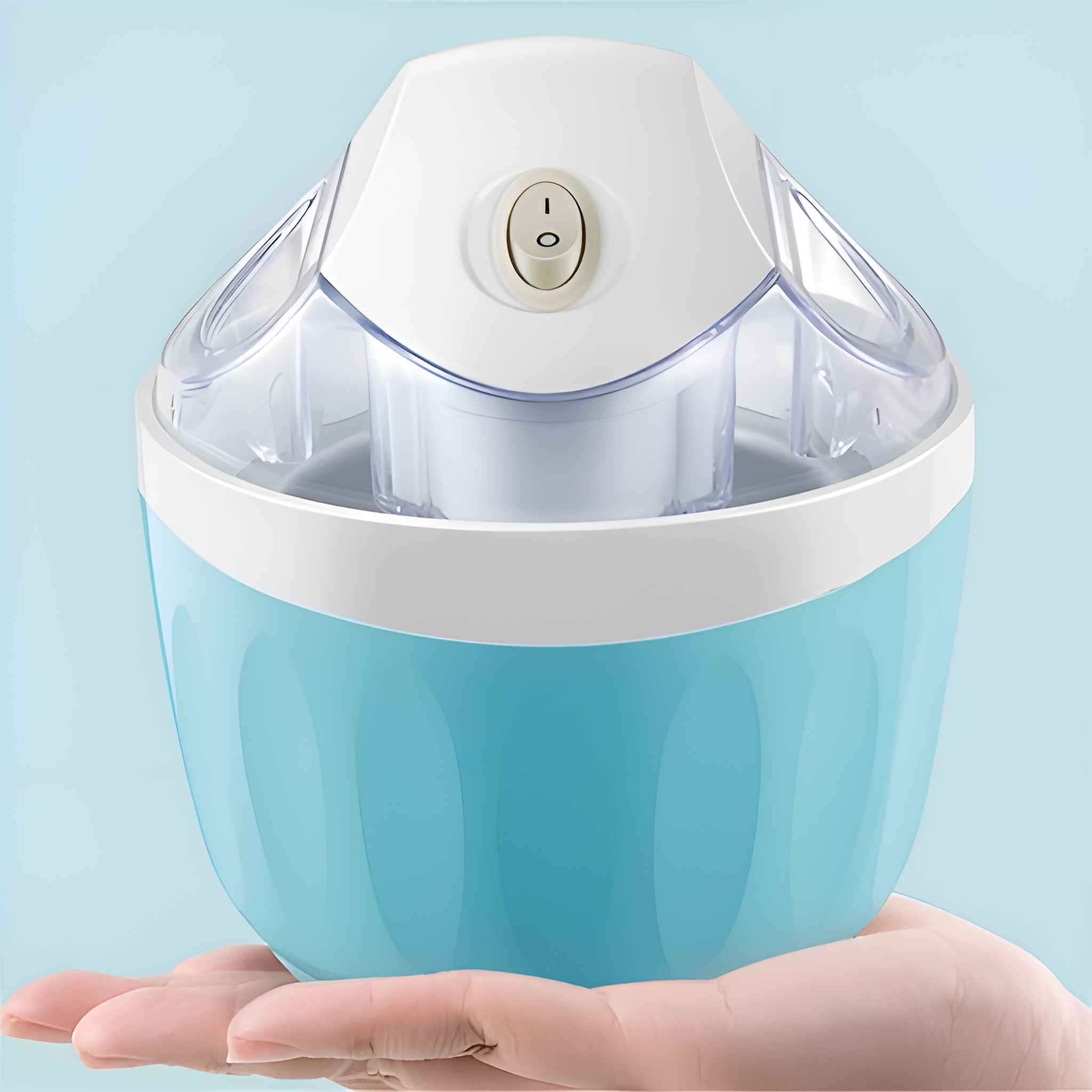 Eine Eismaschine, in einer Hand gehalten, ist hellblau mit weißem Deckel. Sie hat einen transparenten Deckel und einen Ein-/Ausschalter.