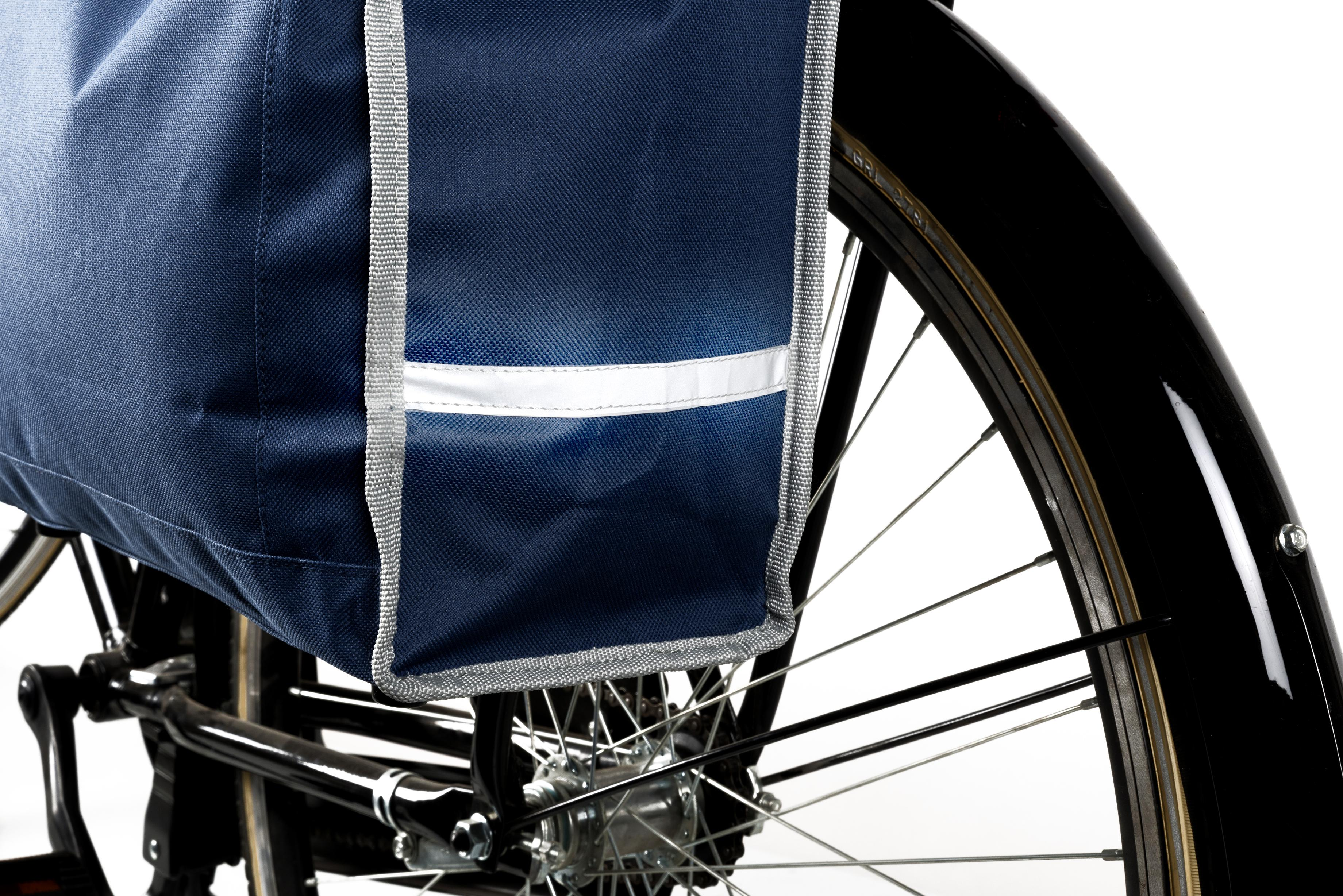 Close-up van een fiets met een blauwe fietstas. Het wiel en de zwarte spatbord zijn zichtbaar. Reflectietape omzoomt de tas.