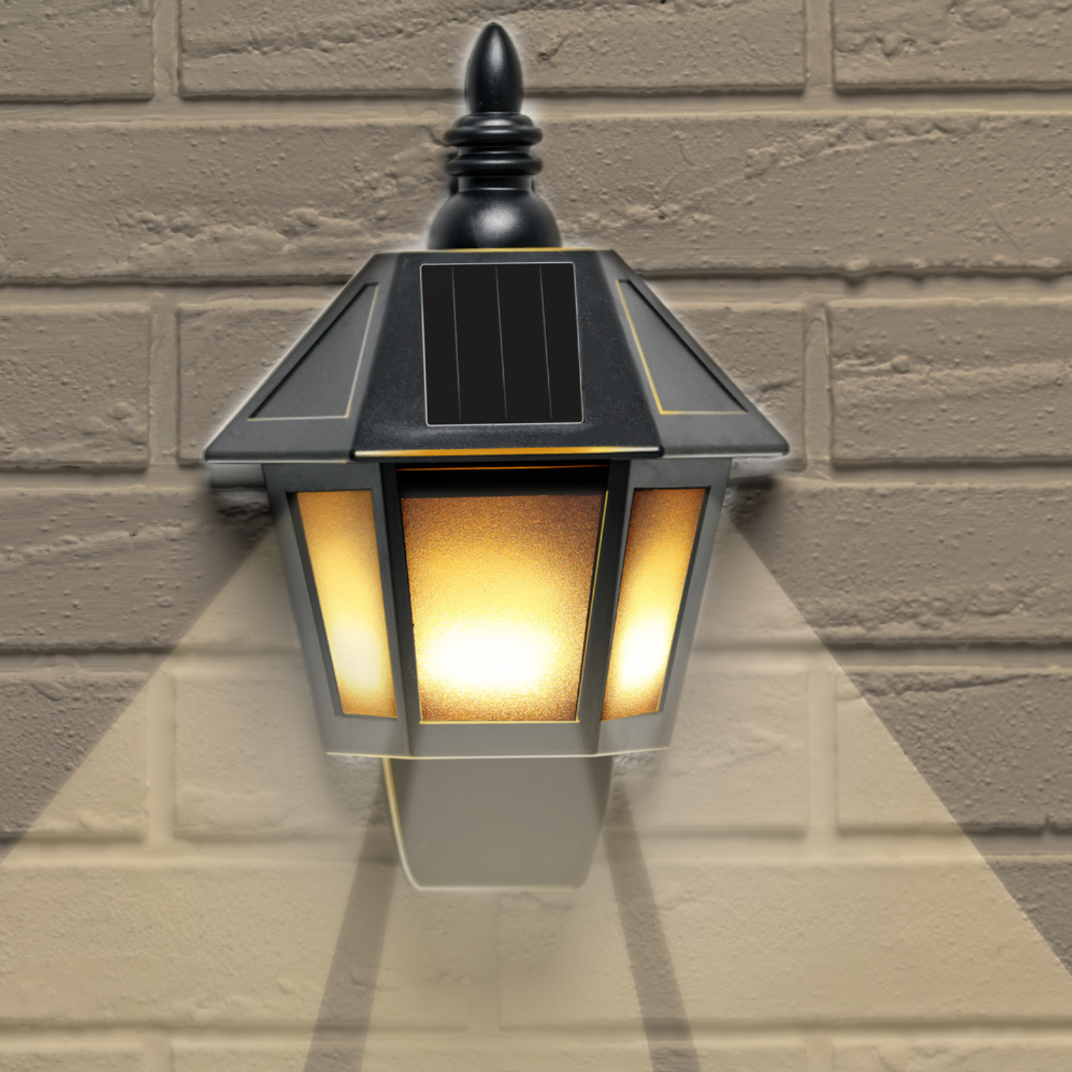A black solar lamp is mounted on a beige brick wall. The lamp is lit, casting a warm glow and shadows on the wall.
