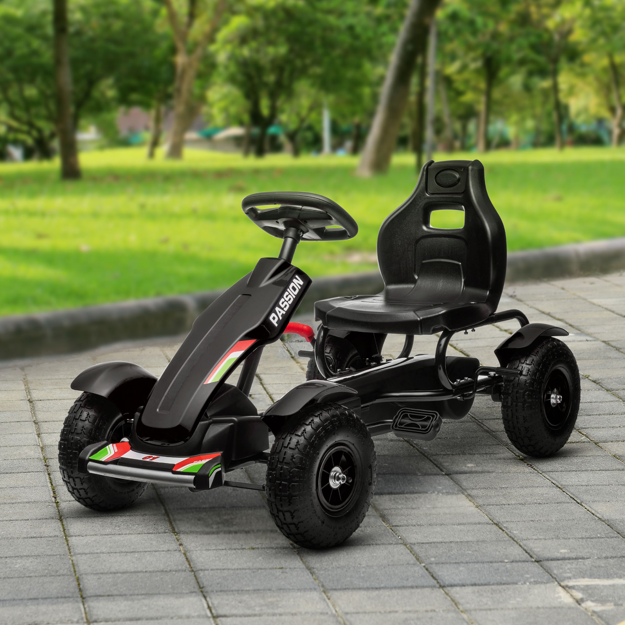 Go-kart a pedali nero su una superficie pavimentata, con alberi verdi sullo sfondo. Il kart è nero e ha la parola "PASSION".