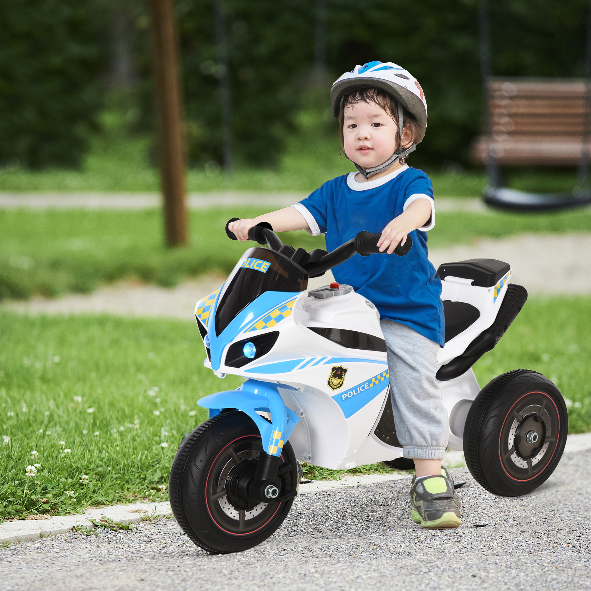 Un bambino con il casco guida una moto della polizia giocattolo su un sentiero del parco. La scena comprende erba, alberi e un'altalena.