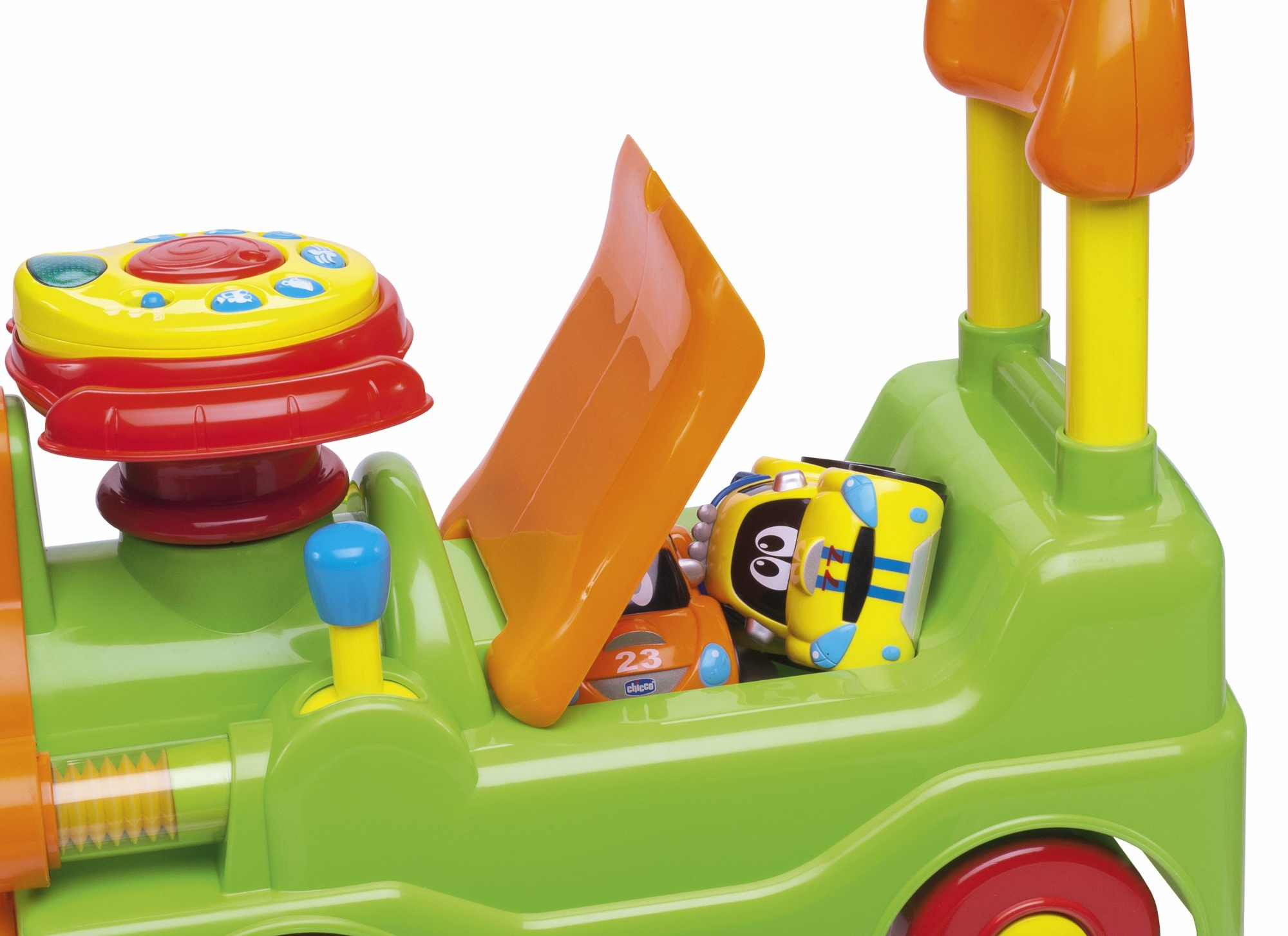 Ein grüner Spielzeugzug mit einer orangefarbenen Rampe, gelben und orangenen Spielzeugautos im Inneren. Ein gelber und roter Aufsatz und gelbe Stangen sind zu sehen.