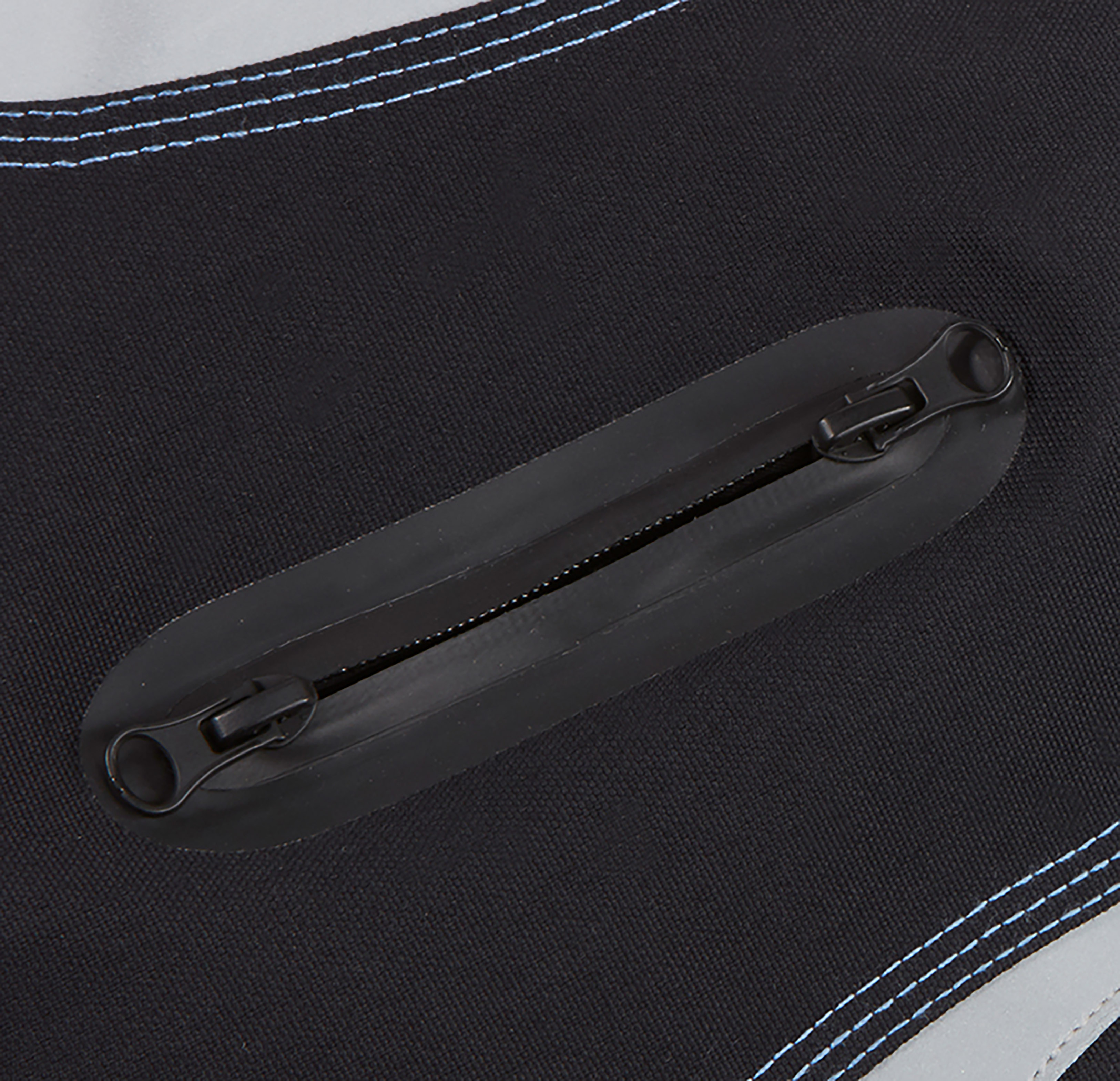Nahaufnahme einer schwarzen Tasche mit schwarzem Reißverschluss. Blaue Nähte sind an den Rändern sichtbar. Ein grauer Fleck ist ebenfalls sichtbar.