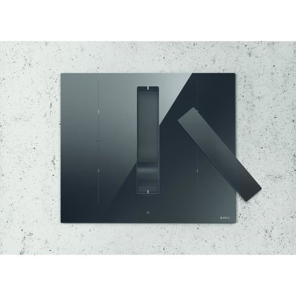 Czarna płyta grzejna ze zintegrowanym okapem spoczywa na jasnoszarej, teksturowanej ścianie. Widoczne są prostokątny otwór wentylacyjny i oddzielny panel.