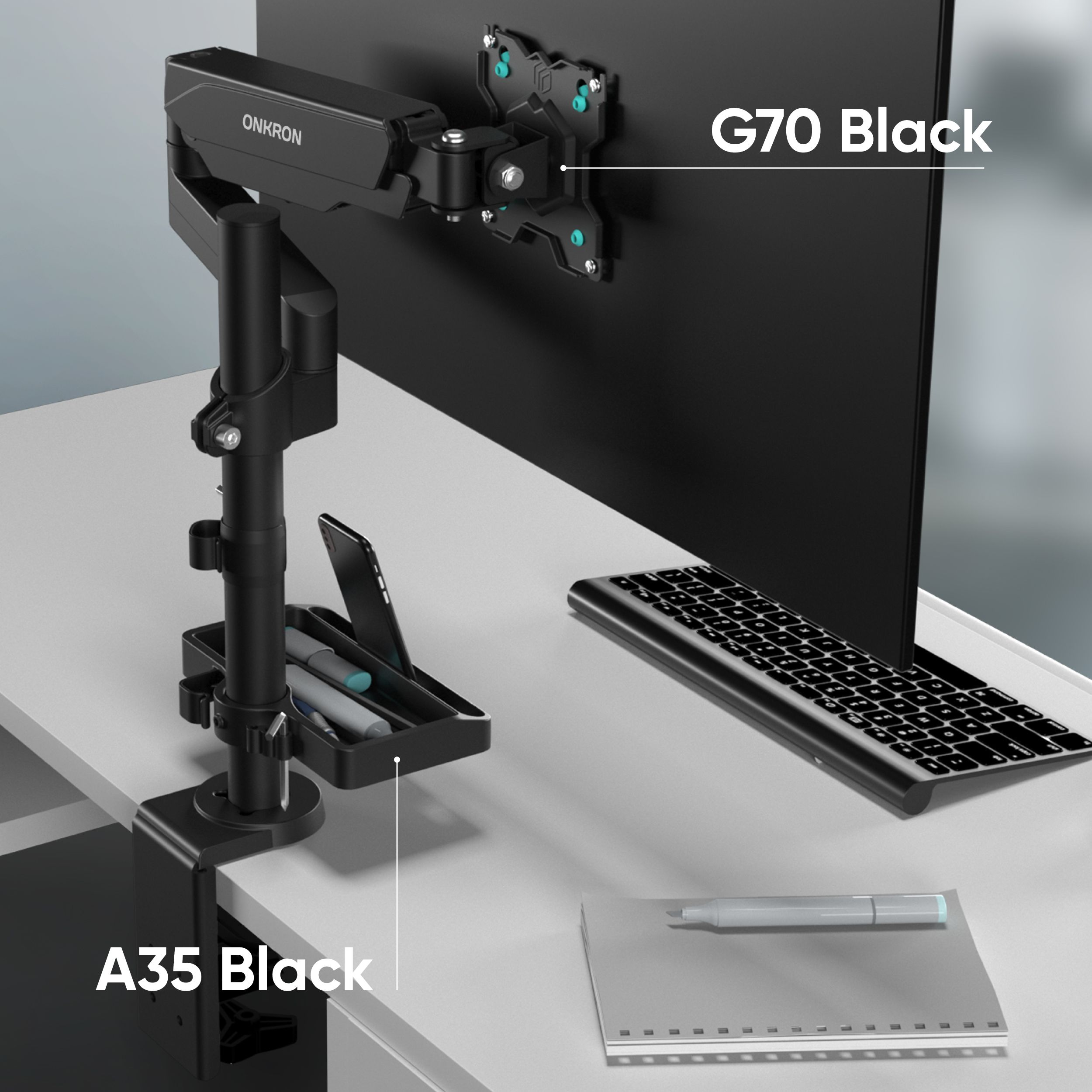 Braccio monitor nero, tastiera, penne e monitor su una scrivania. Etichette: A35 Black e G70 Black.