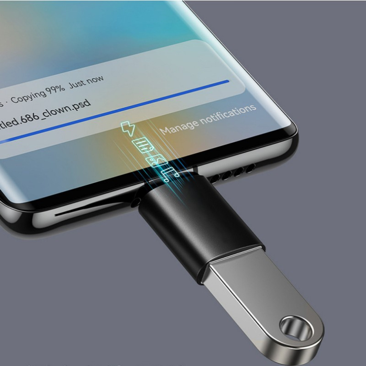 Smartfon jest podłączony do dysku USB. Ekran pokazuje trwający transfer plików. Dysk jest srebrny i czarny.