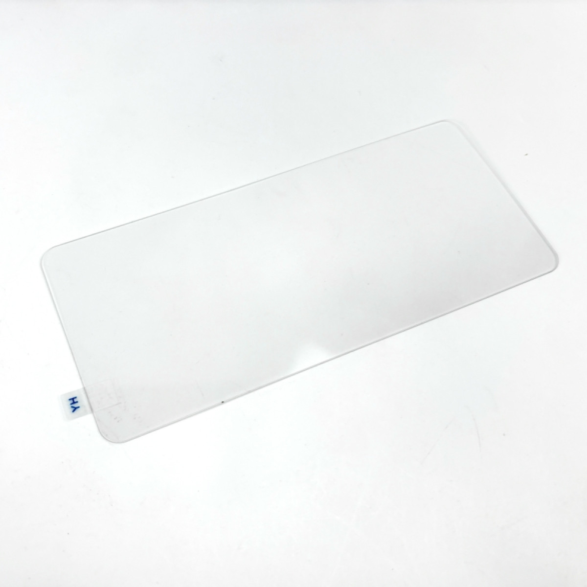 Un foglio di plastica rettangolare trasparente su una superficie bianca. Ha angoli arrotondati e una piccola etichetta blu con 'YH'.