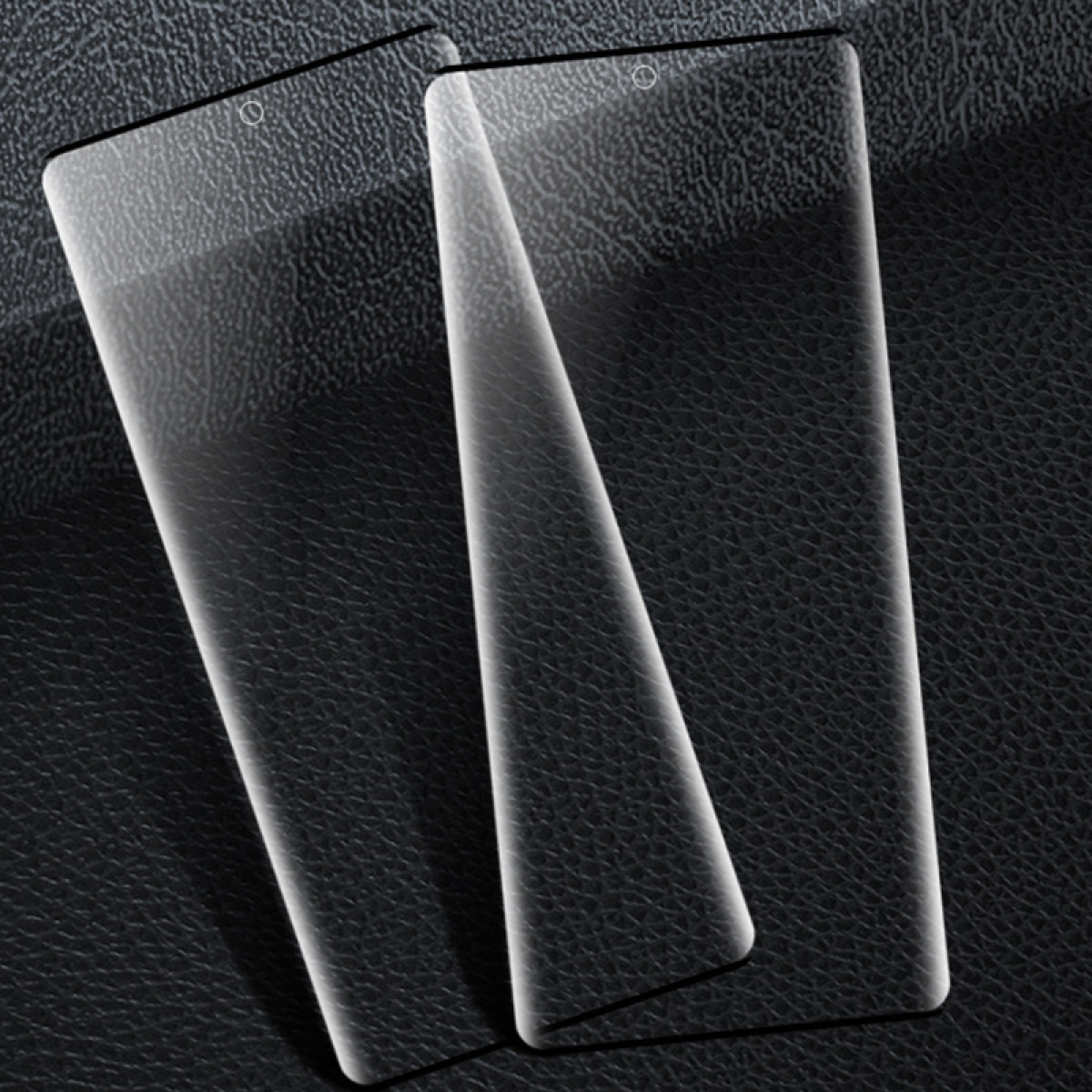 Dwie przezroczyste osłony ekranu na teksturowanej czarnej powierzchni. Każda ma wycięcie na aparat. Są lekko pochylone, rzucając cienie.