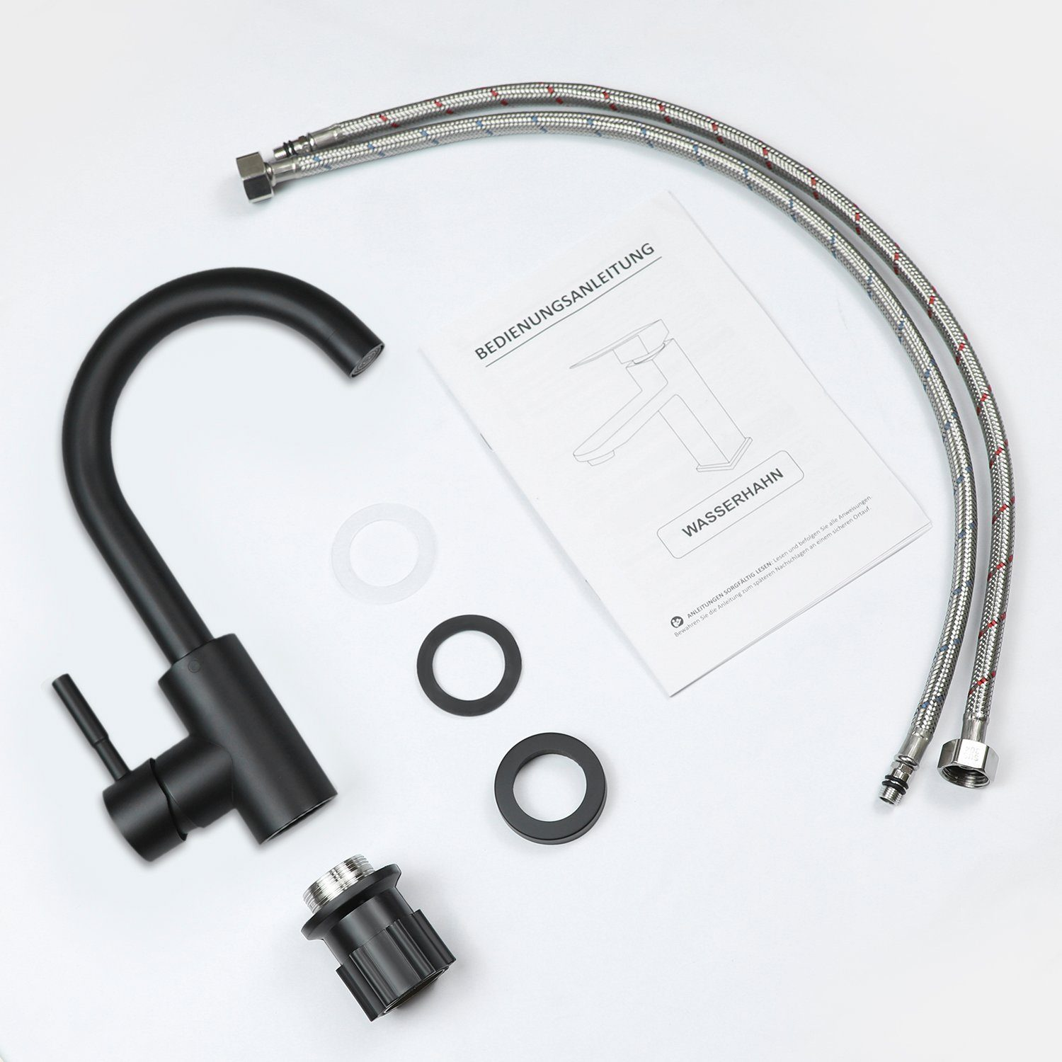 Czarne elementy kranu, węże i instrukcja są ułożone na białej powierzchni. Zawiera kran, podkładki i instrukcję z niemieckim tekstem.