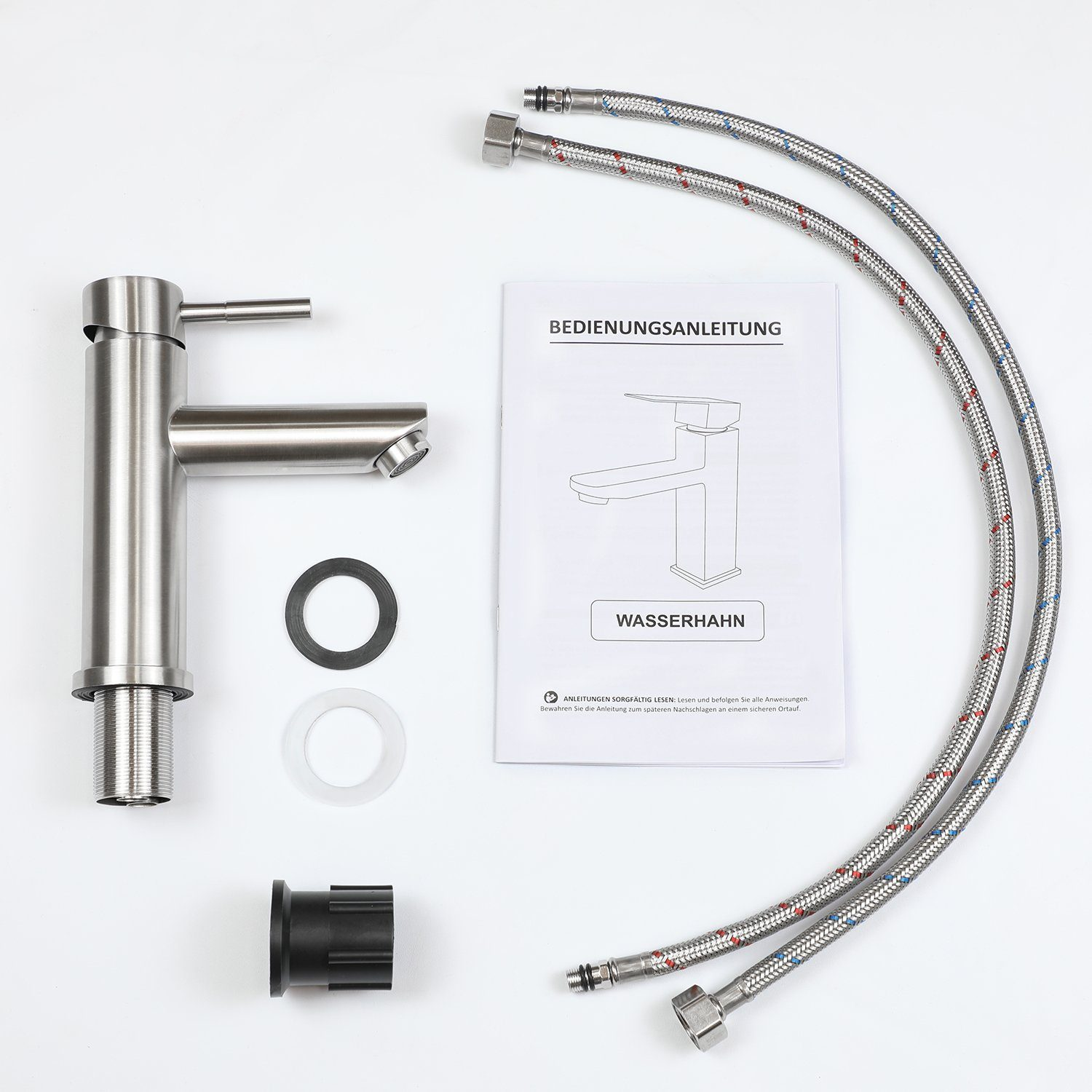 Bateria ze stali nierdzewnej, węże i instrukcja obsługi leżą na białej powierzchni. Obecne są również różne części, takie jak podkładki i złącze.