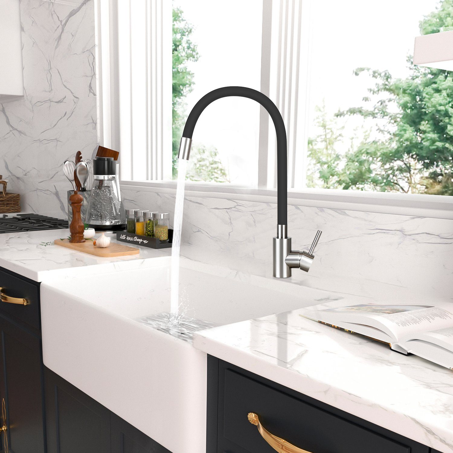 Zlew kuchenny z czarną baterią. Woda wlewa się do białego zlewu. Marmurowe blaty i okno z drzewami w tle.