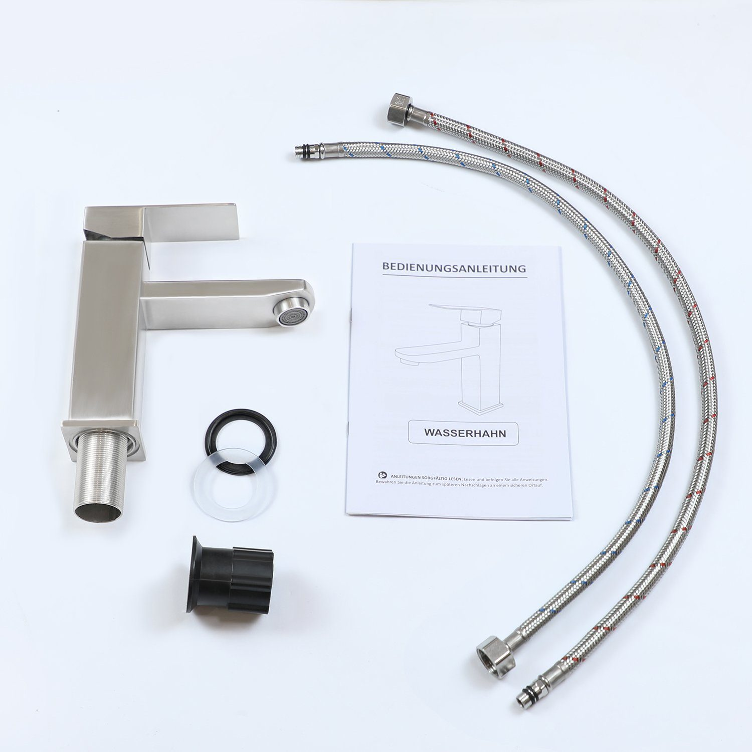 Zestaw kranu z instrukcją, dwoma wężami i kilkoma elementami na białej powierzchni. Kątowy i srebrny kran.