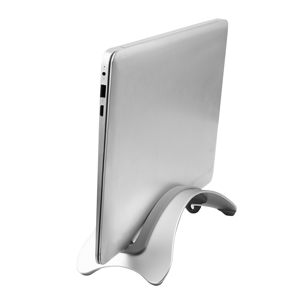 Srebrny laptop jest trzymany na srebrnym stojaku. Laptop jest zamknięty i ustawiony pod kątem. Stojak ma zakrzywioną konstrukcję.