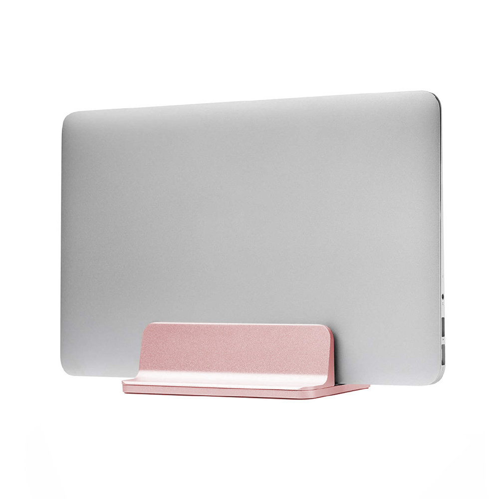 Una computadora portátil plateada se sostiene en un soporte rosa. El soporte es horizontal con una parte trasera vertical, todo sobre un fondo blanco.